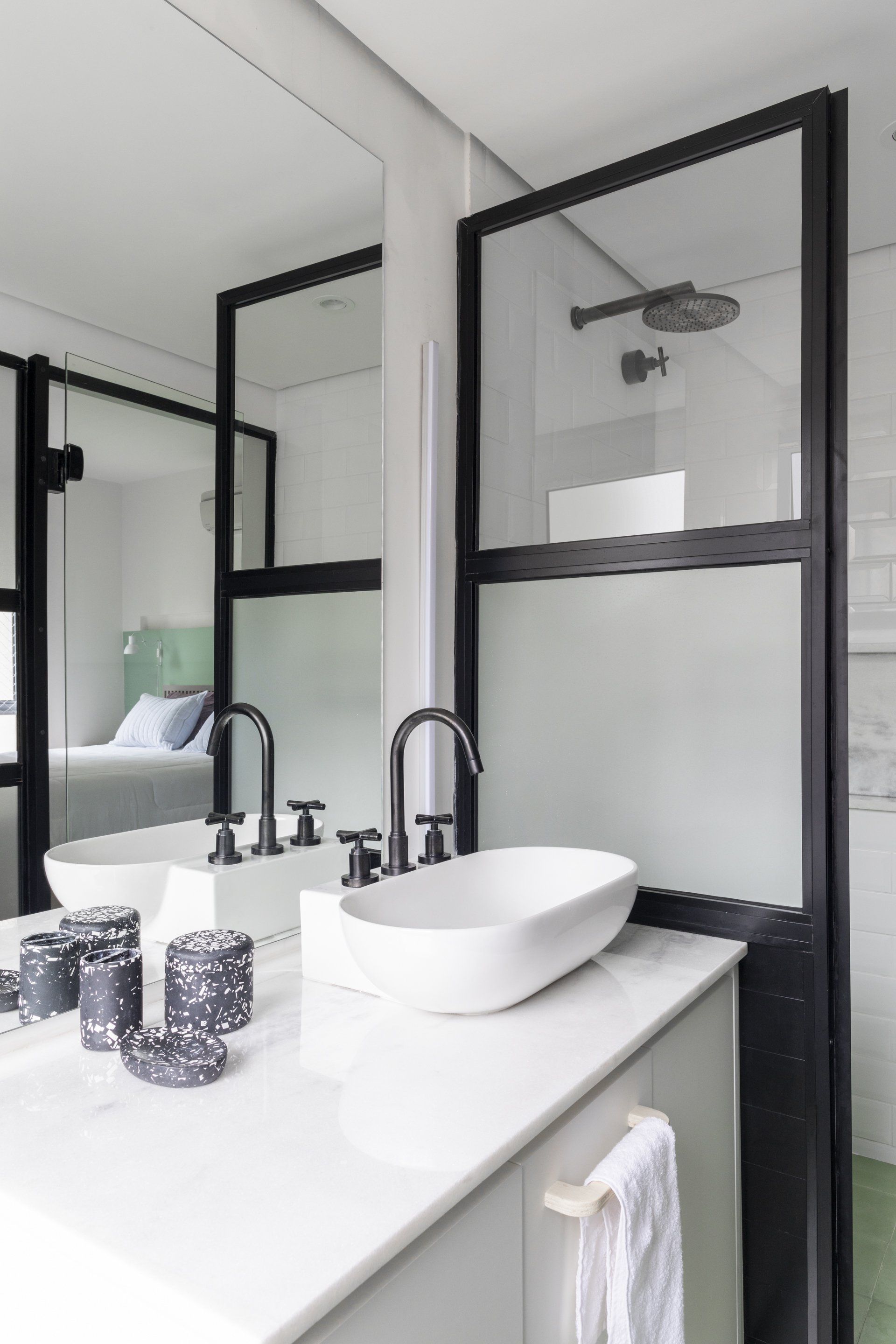 Um banheiro com pia, espelho e chuveiro.