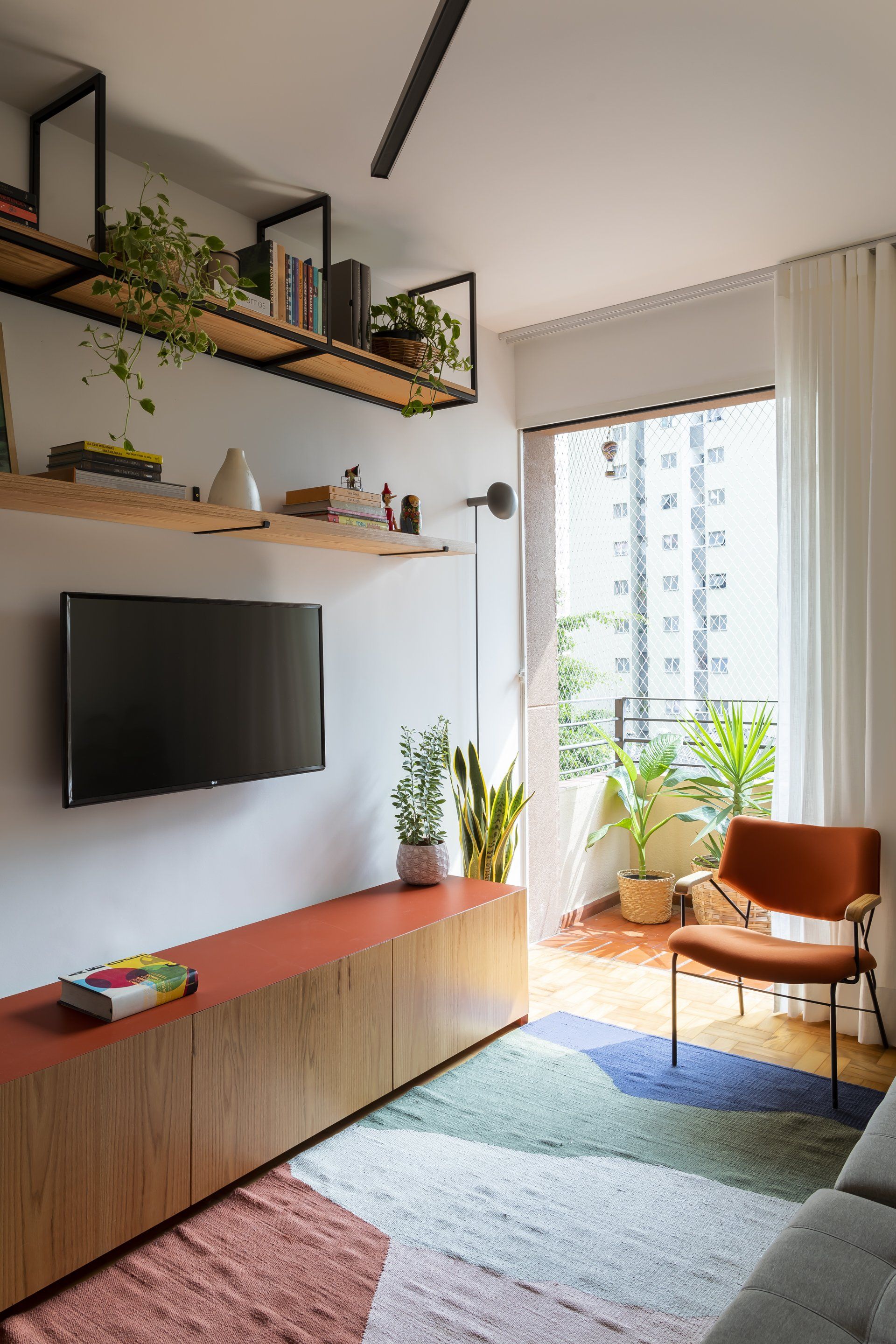 Uma sala de estar com TV de tela plana montada na parede.