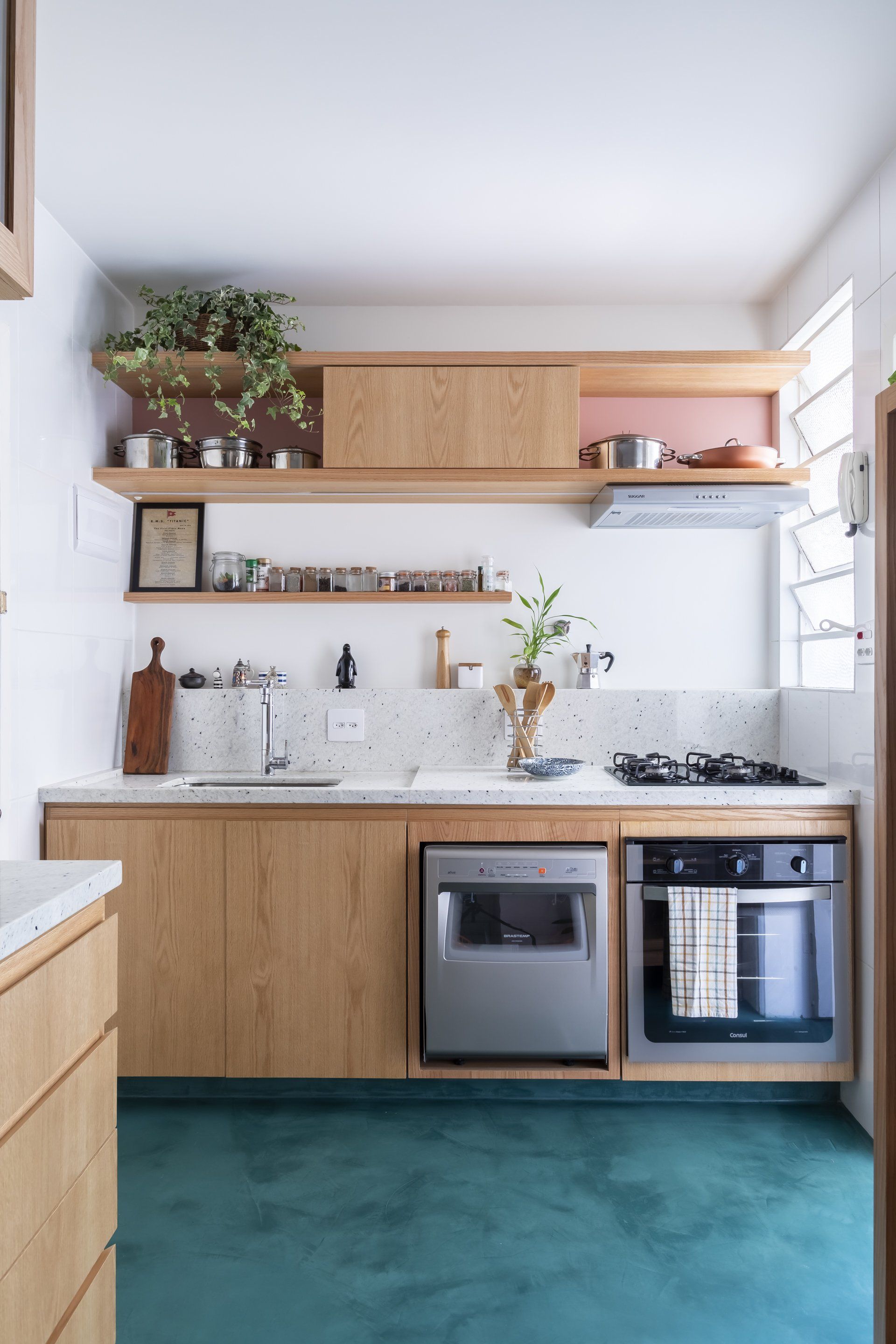Uma cozinha com armários de madeira e piso verde.