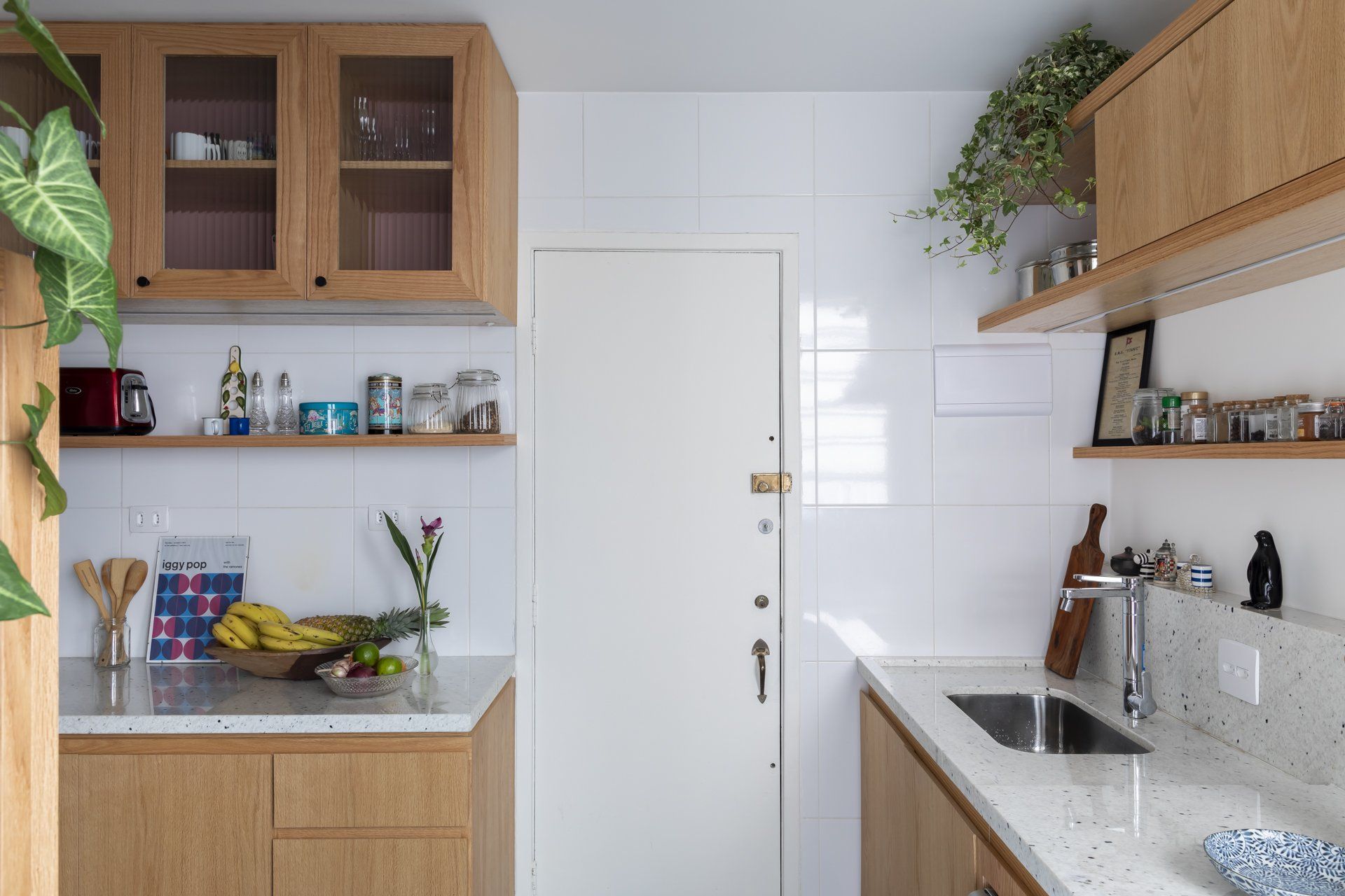 Uma cozinha com armários de madeira, pia e porta.