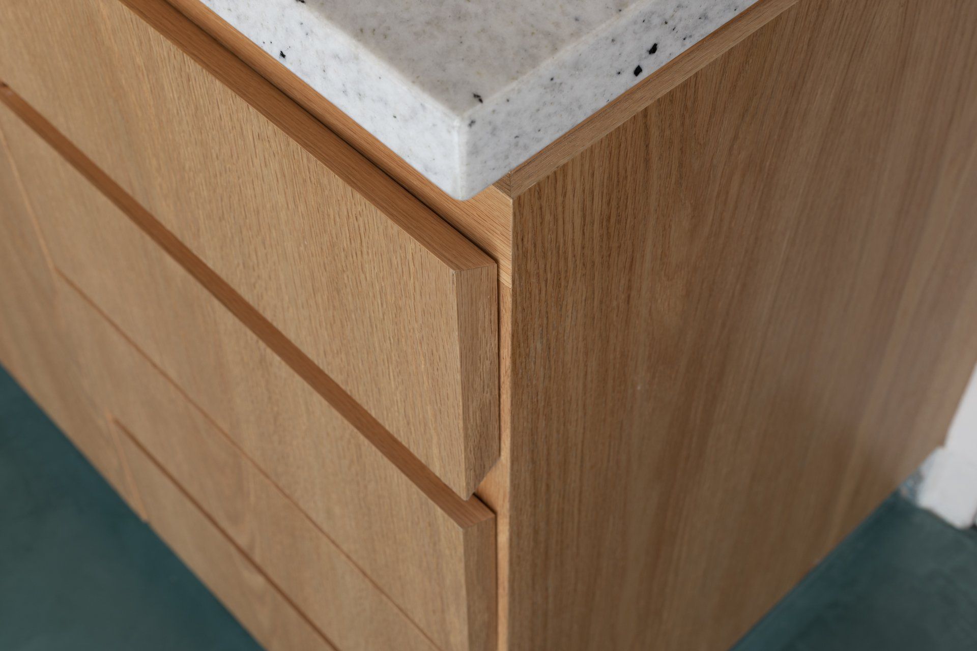 Um close de um armário de madeira com gavetas e uma bancada.