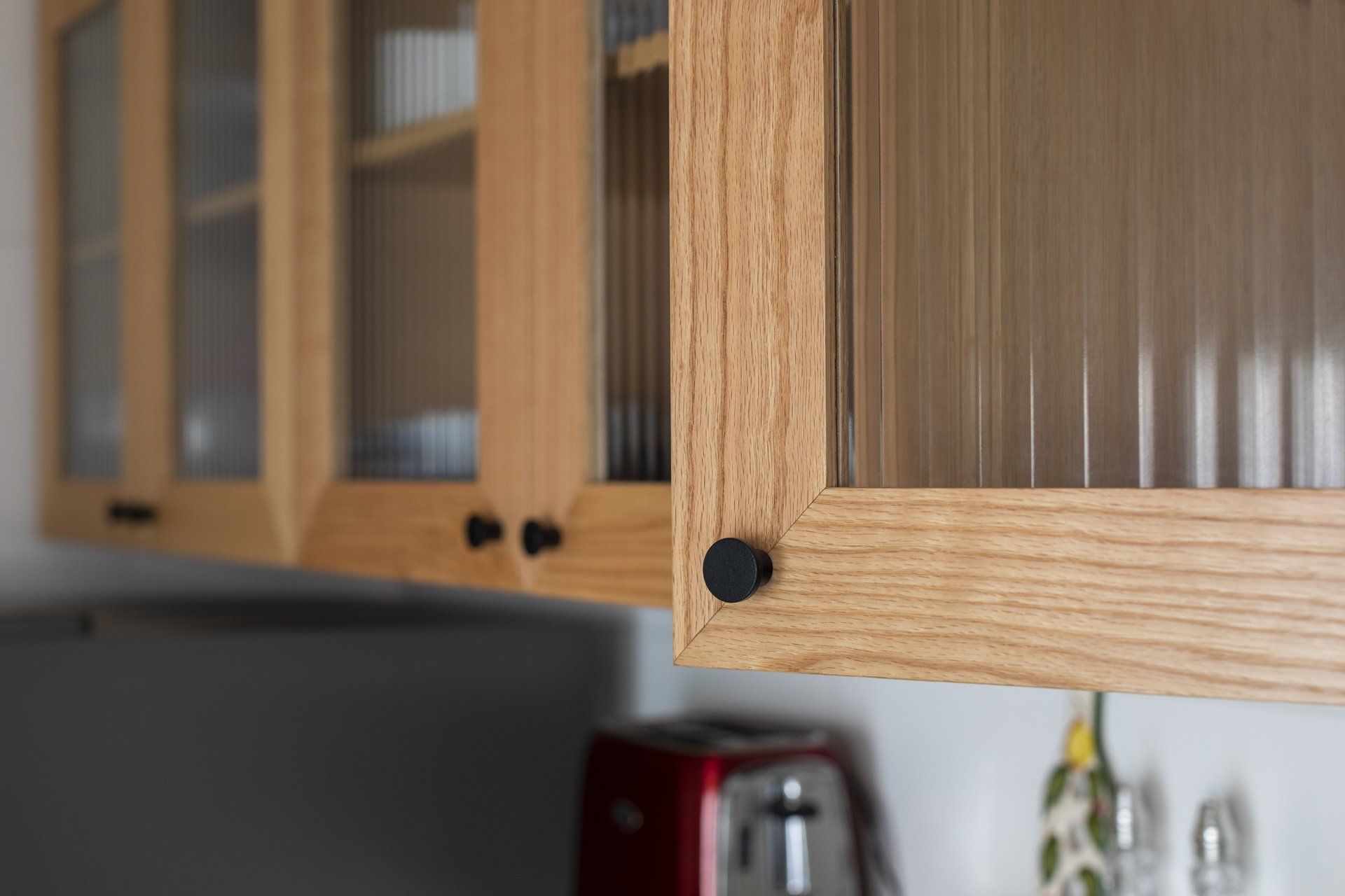 Uma cozinha com armários de madeira e portas de vidro.