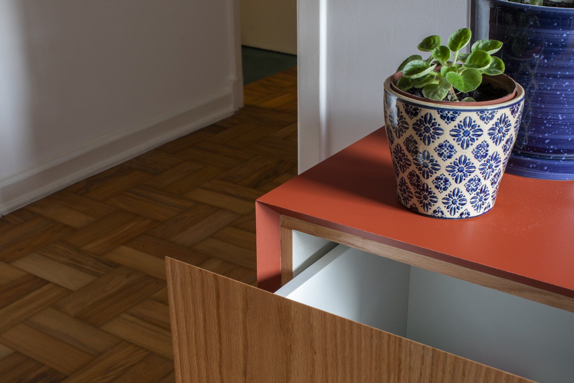 Um vaso de planta está em cima de uma mesa de madeira.