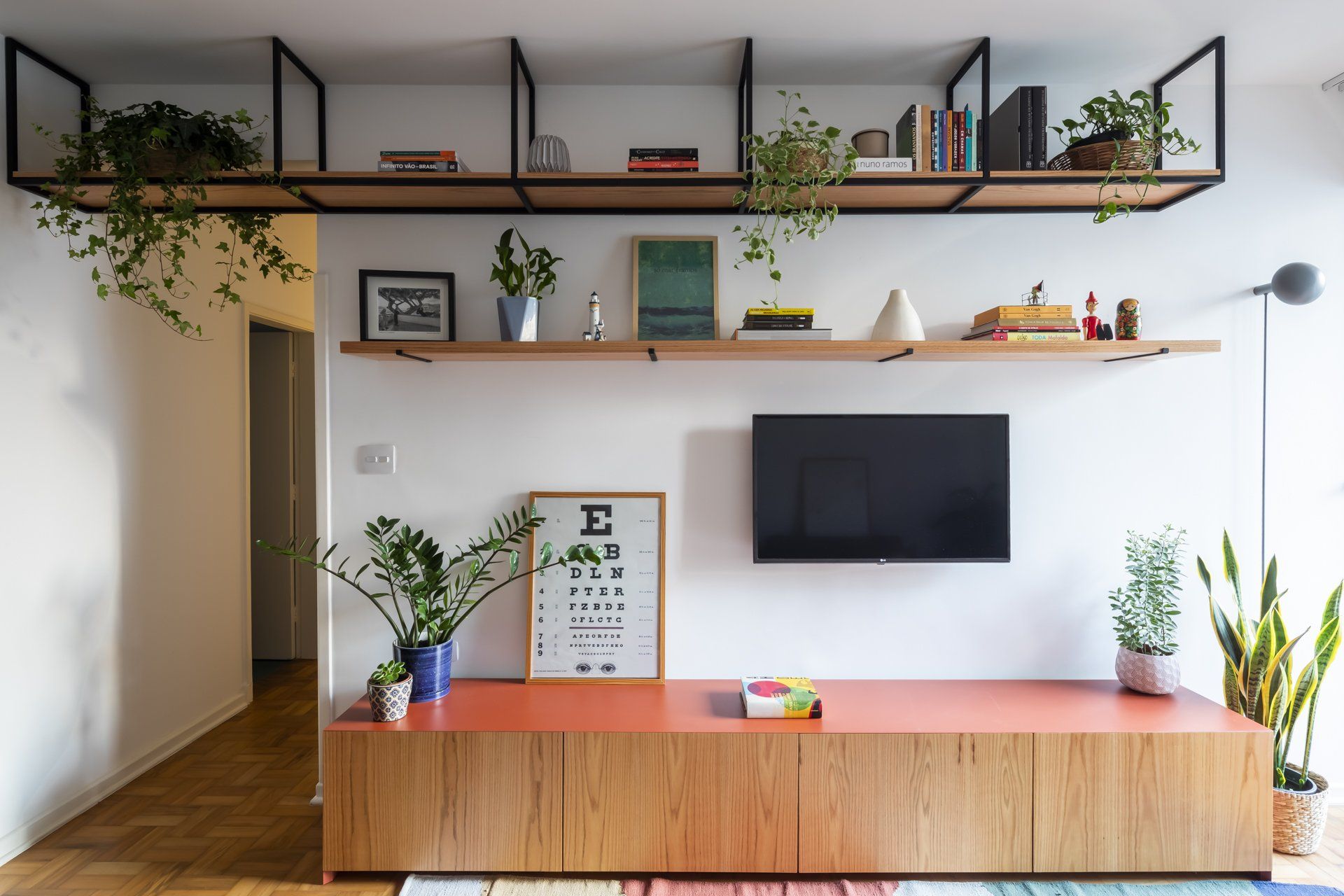 Uma sala de estar com TV de tela plana e prateleiras.