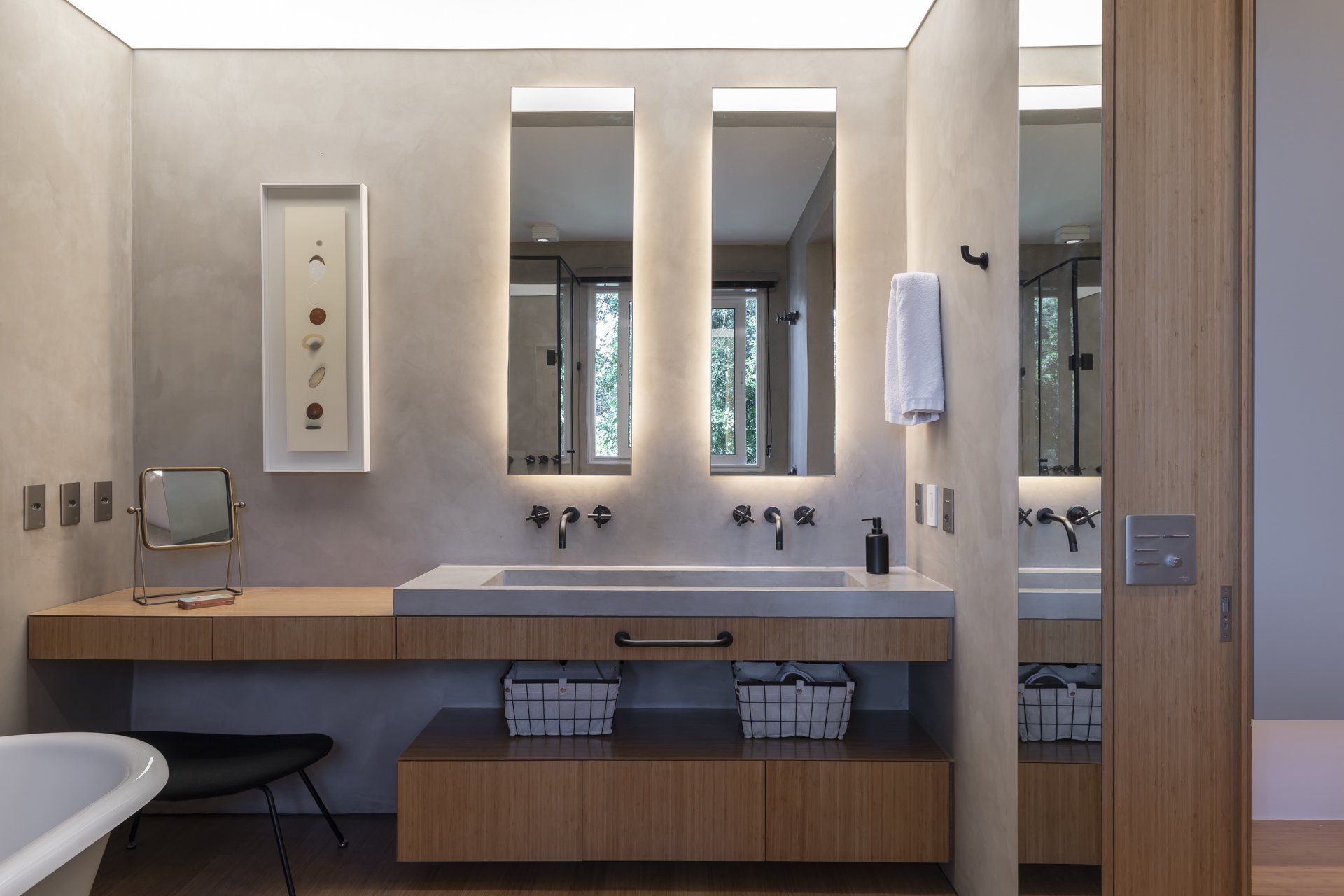 Uma casa de banho com dois lavatórios, dois espelhos e uma banheira.