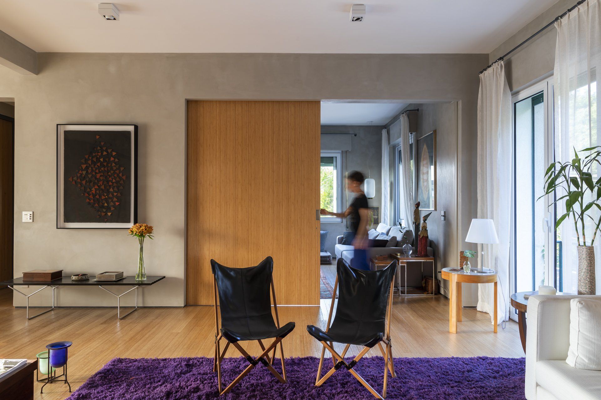 Uma sala com duas cadeiras e um tapete roxo.