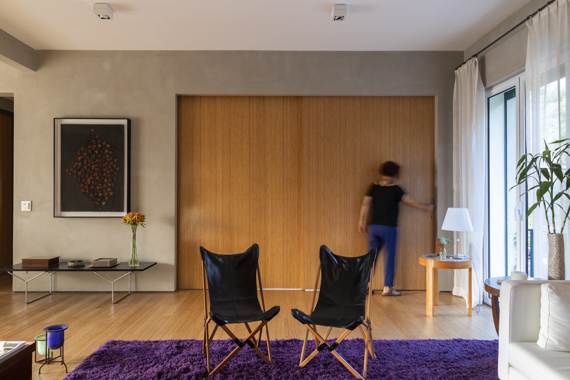 Uma sala com duas cadeiras dobráveis ​​e um tapete roxo.