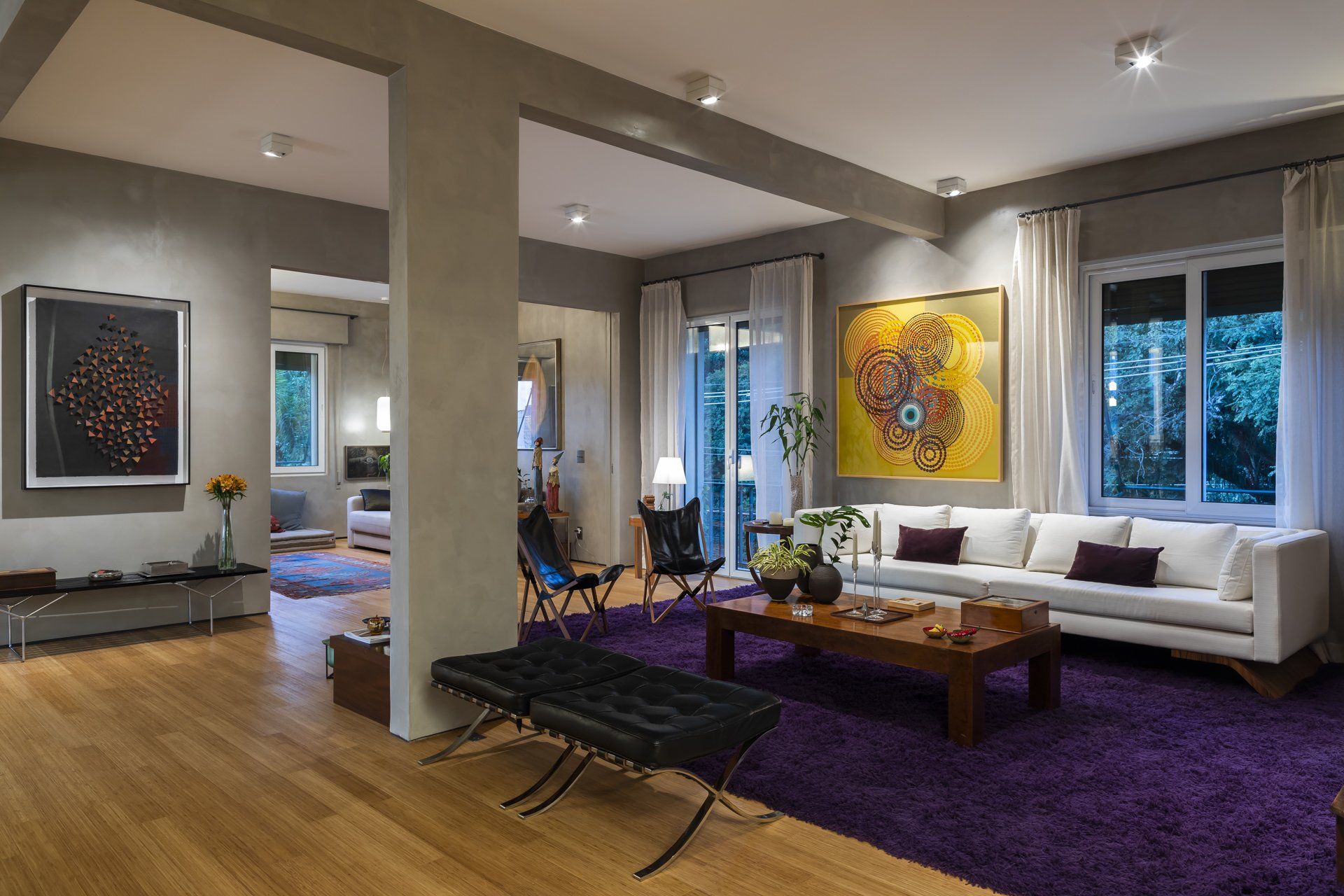 Uma sala de estar com tapete roxo e sofá branco