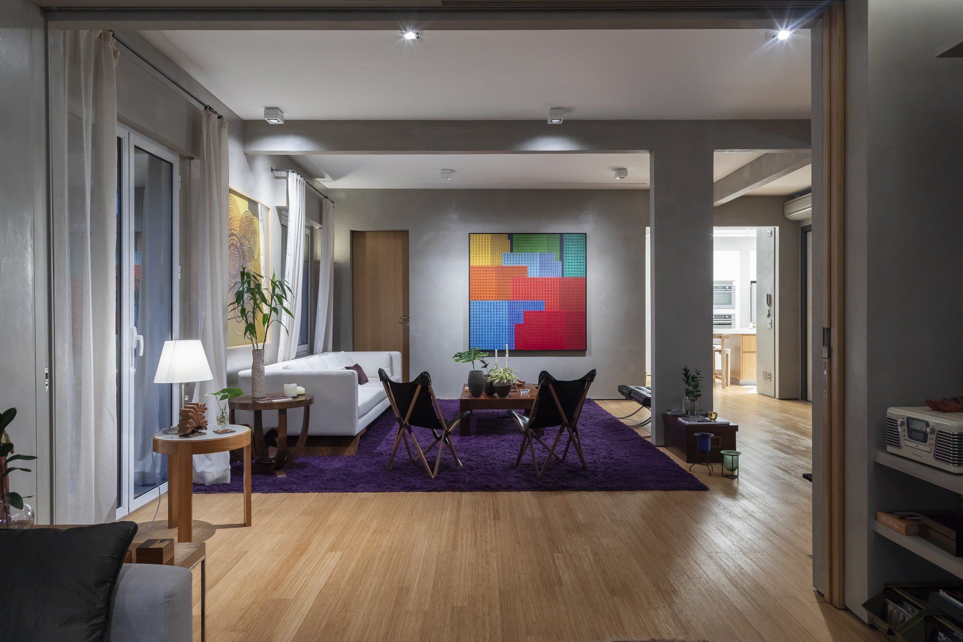 Uma sala com tapete roxo e uma pintura na parede.