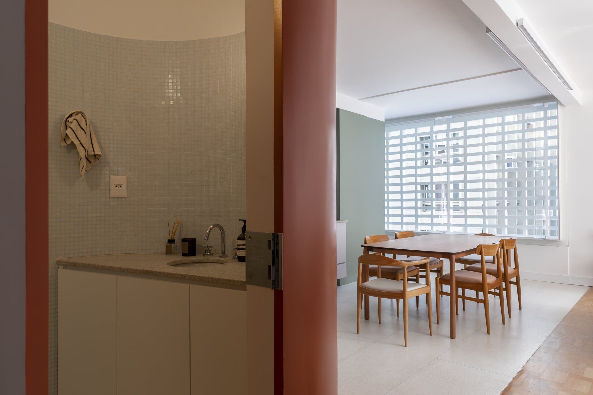 Uma cozinha com pia e uma sala de jantar com mesa e cadeiras.