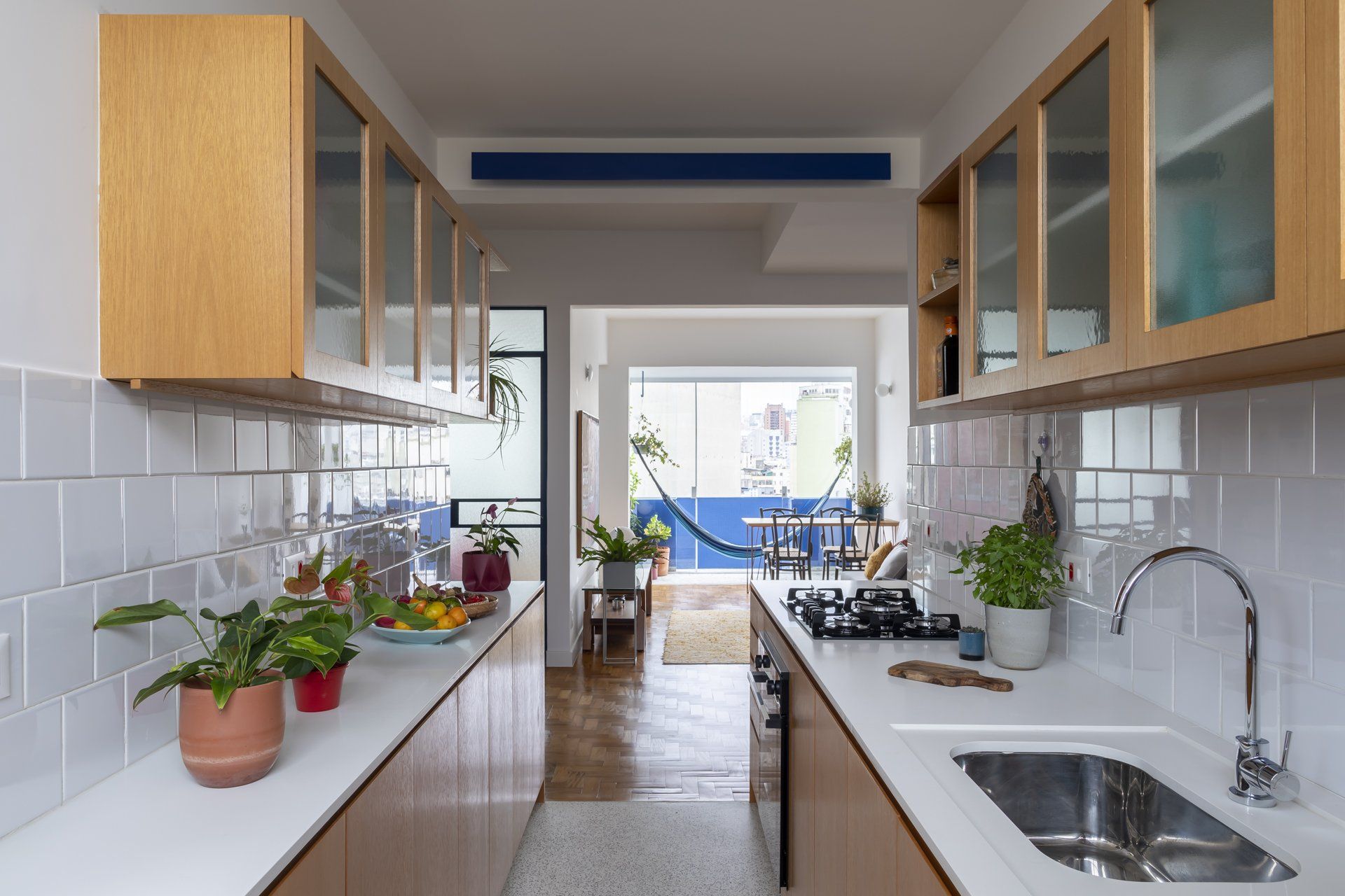 Cozinha com pia, fogão, armários e rede.