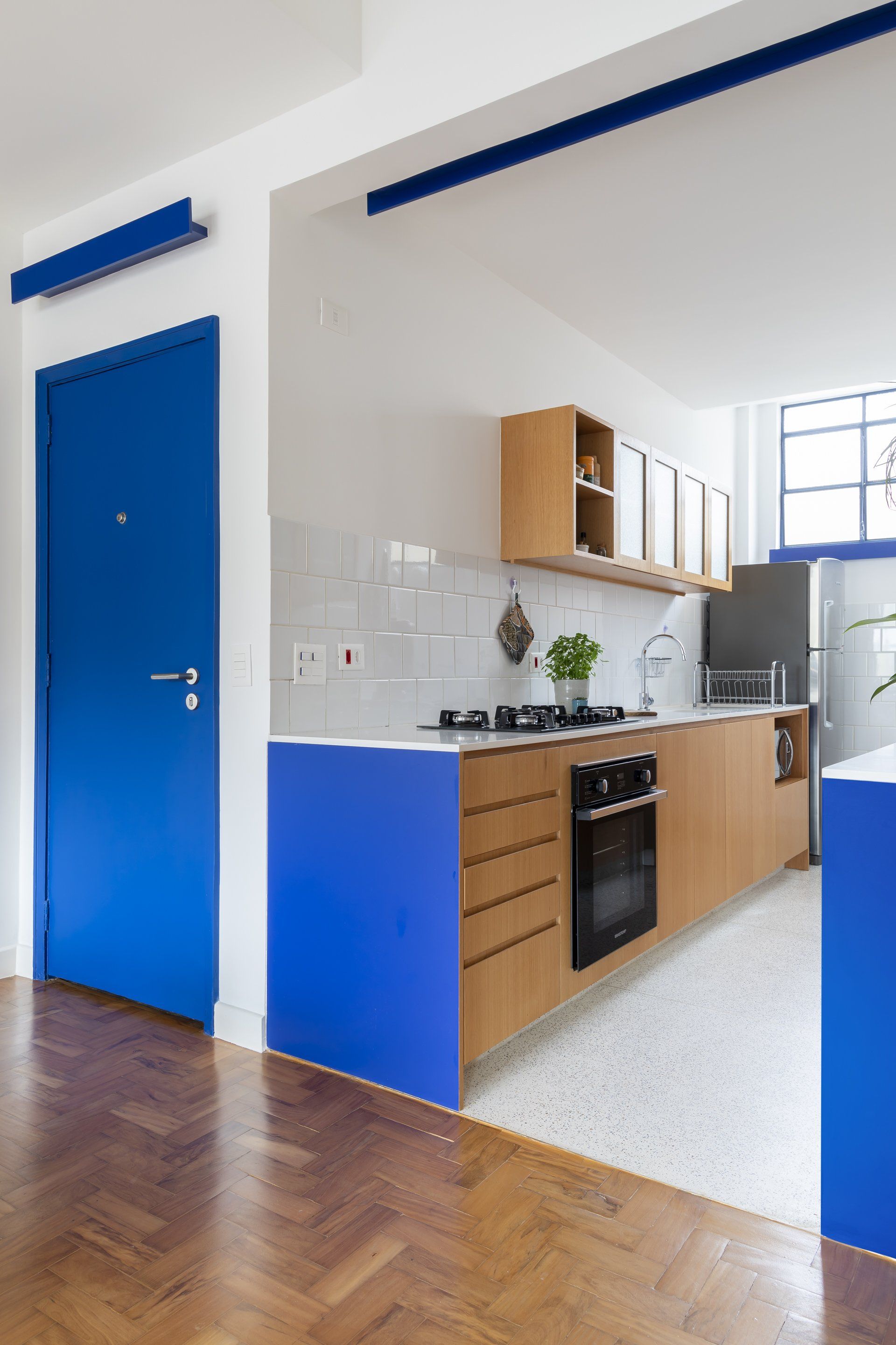 Uma cozinha com armários azuis e uma porta azul
