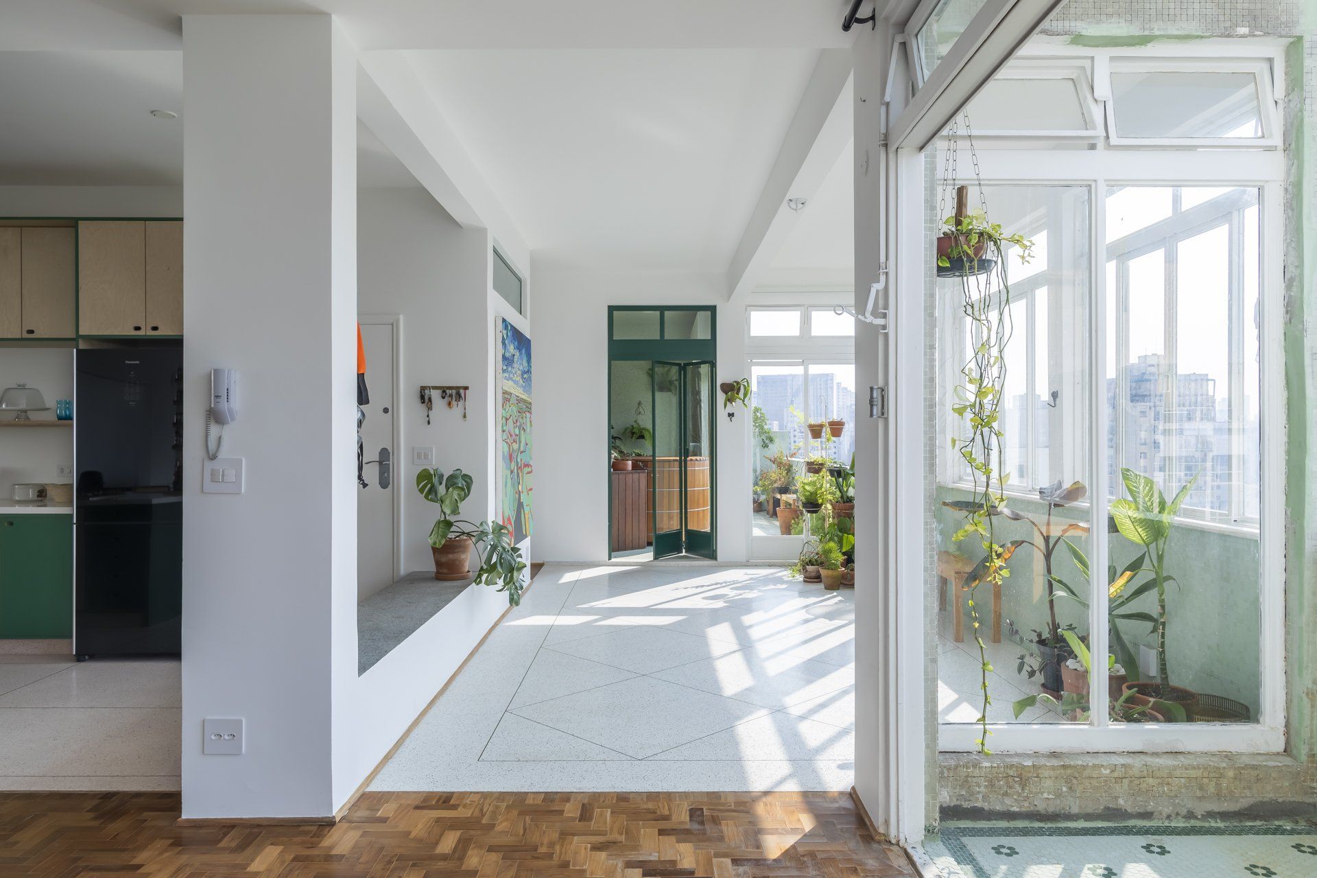 Uma sala grande com muitas janelas e piso de madeira.