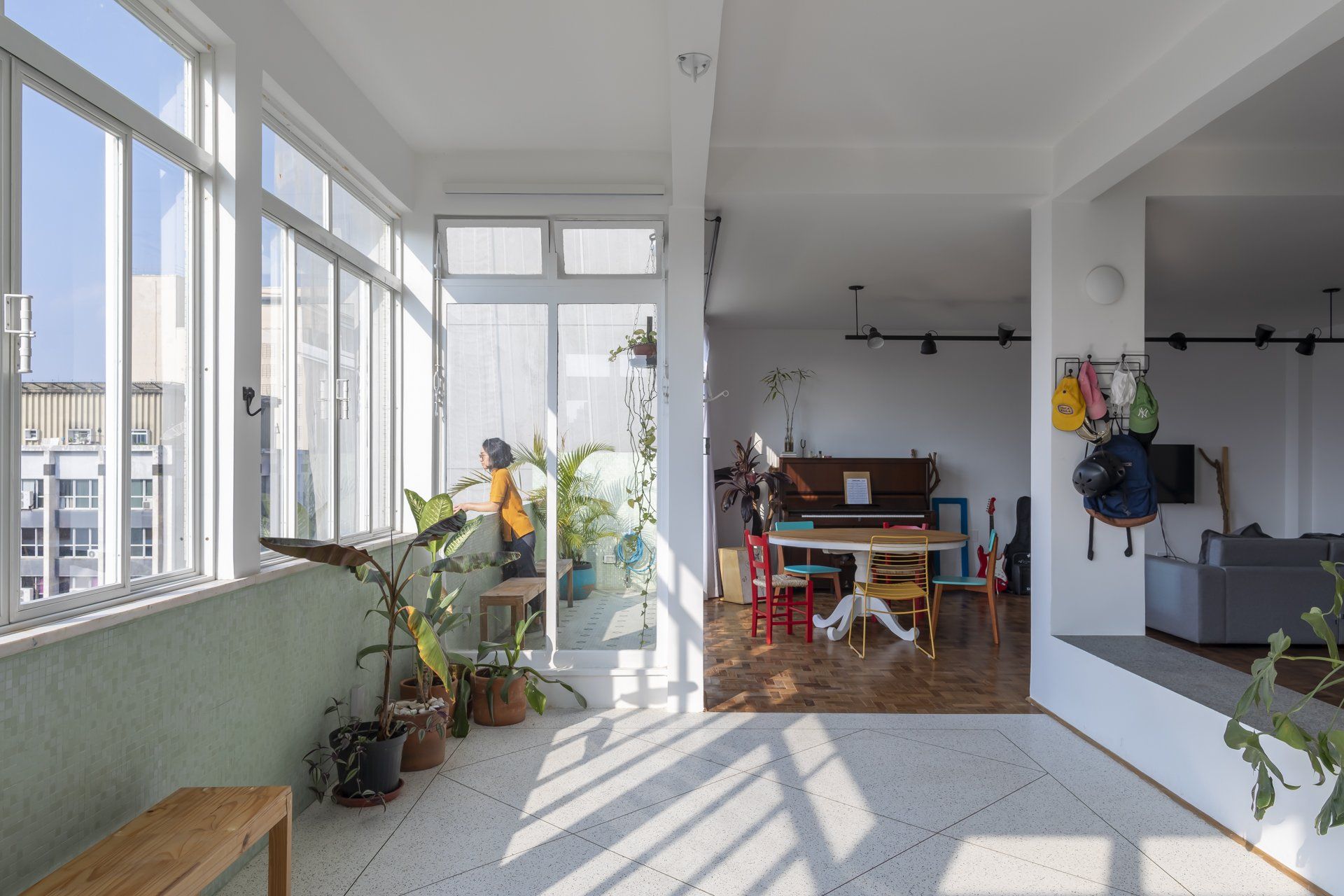 Uma sala grande com muitas janelas e uma mesa e cadeiras.