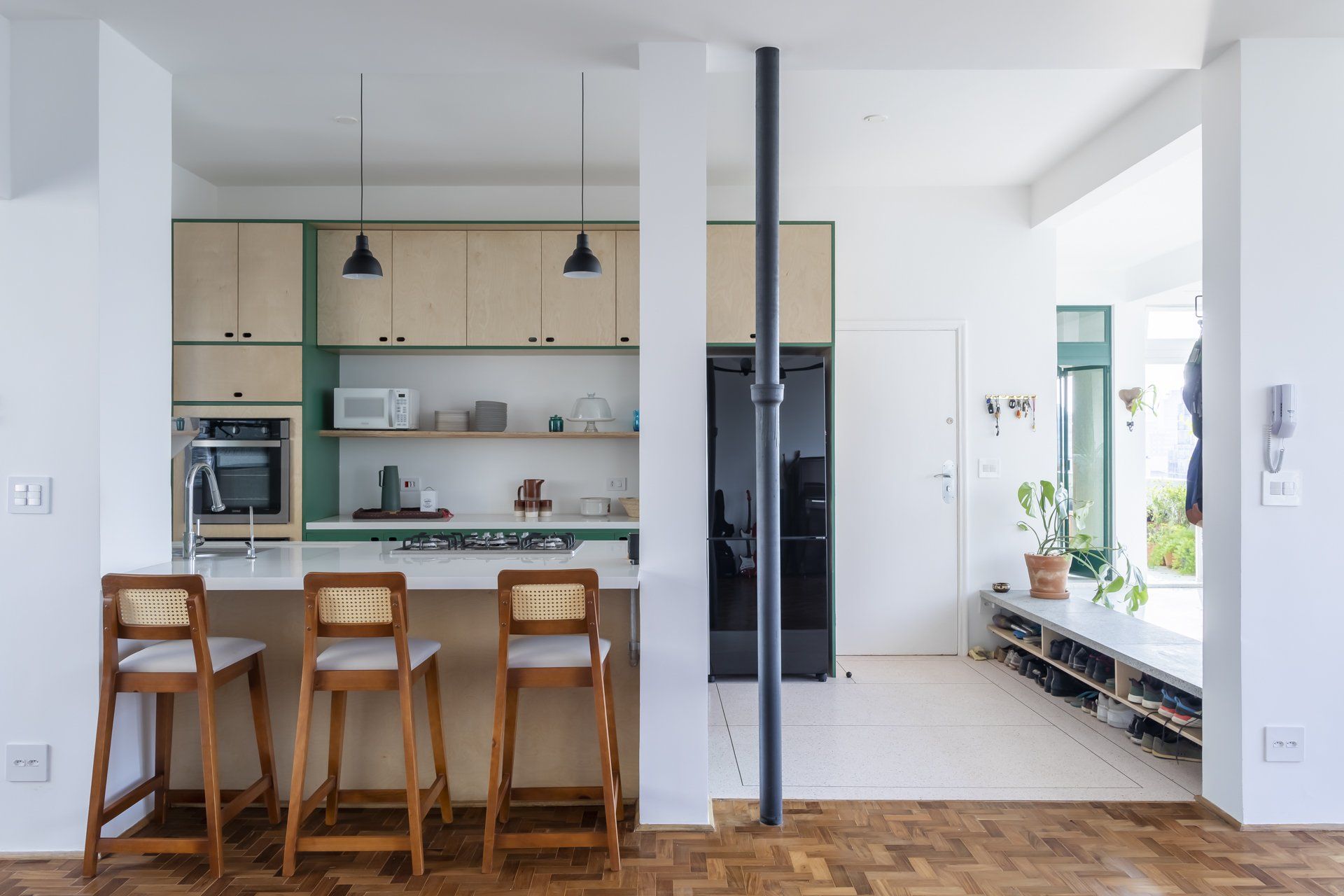 Uma cozinha com bar e bancos e uma geladeira.