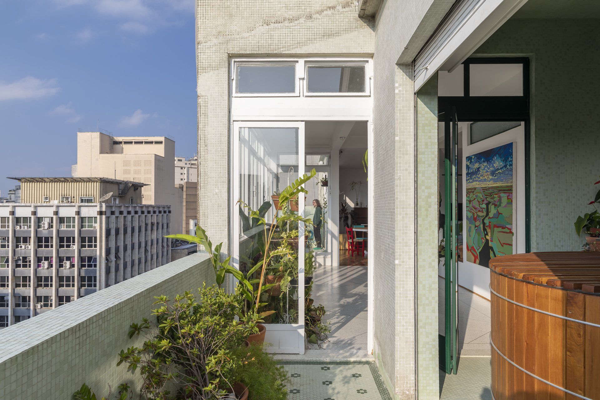 Uma varanda com porta de vidro deslizante e banheira de madeira.