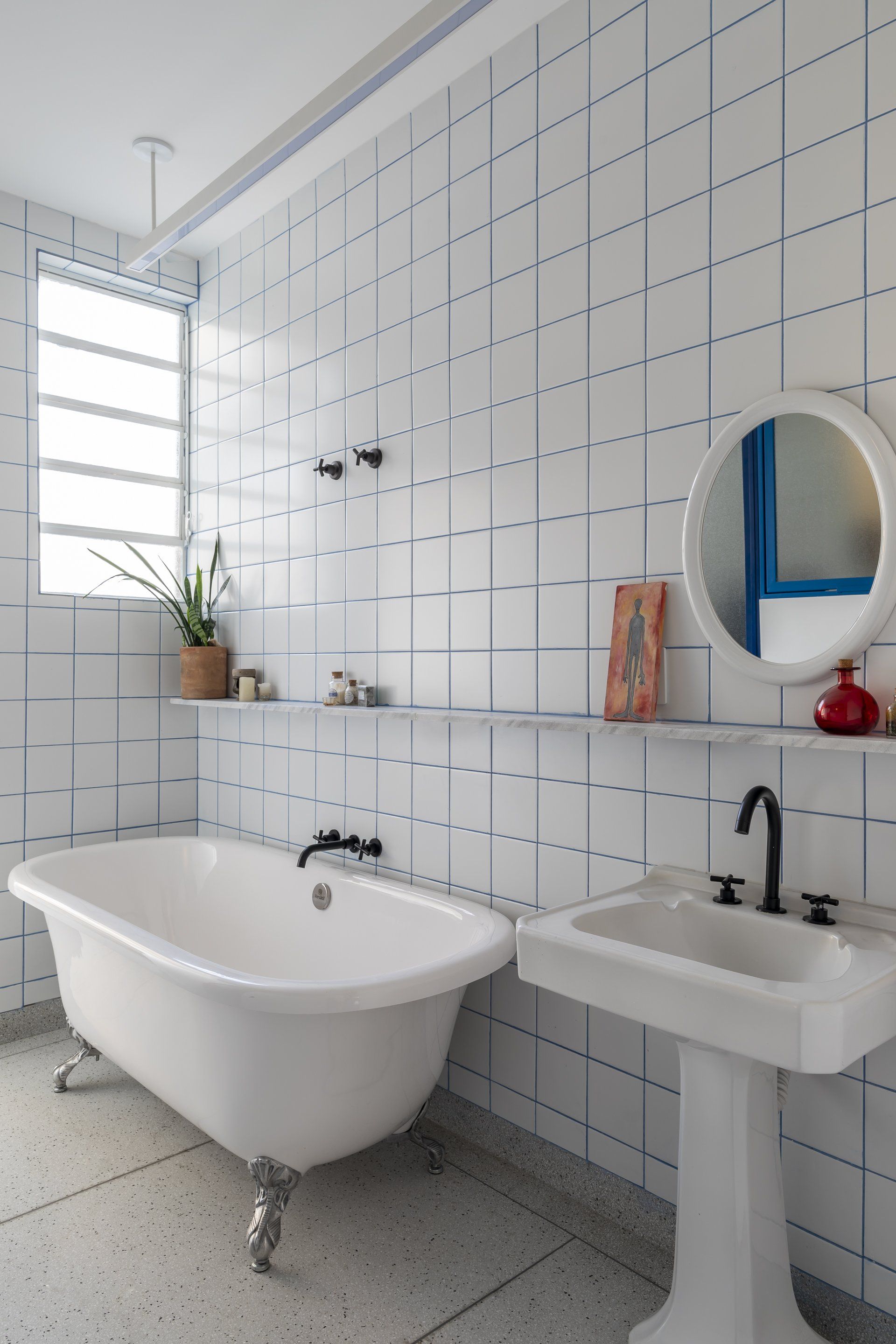 Um banheiro com banheira, pia e espelho.