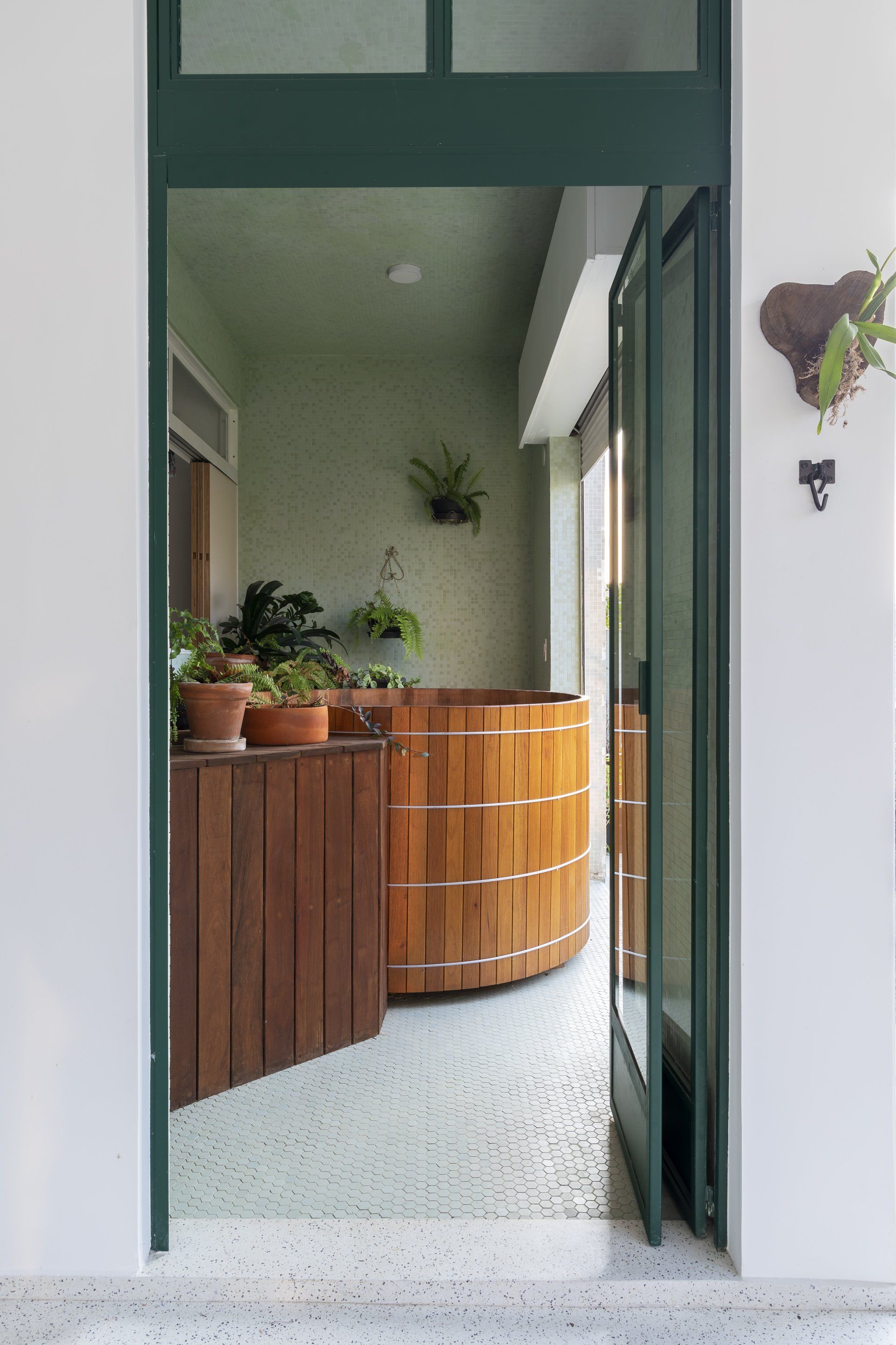 Há uma banheira de madeira no meio da sala.