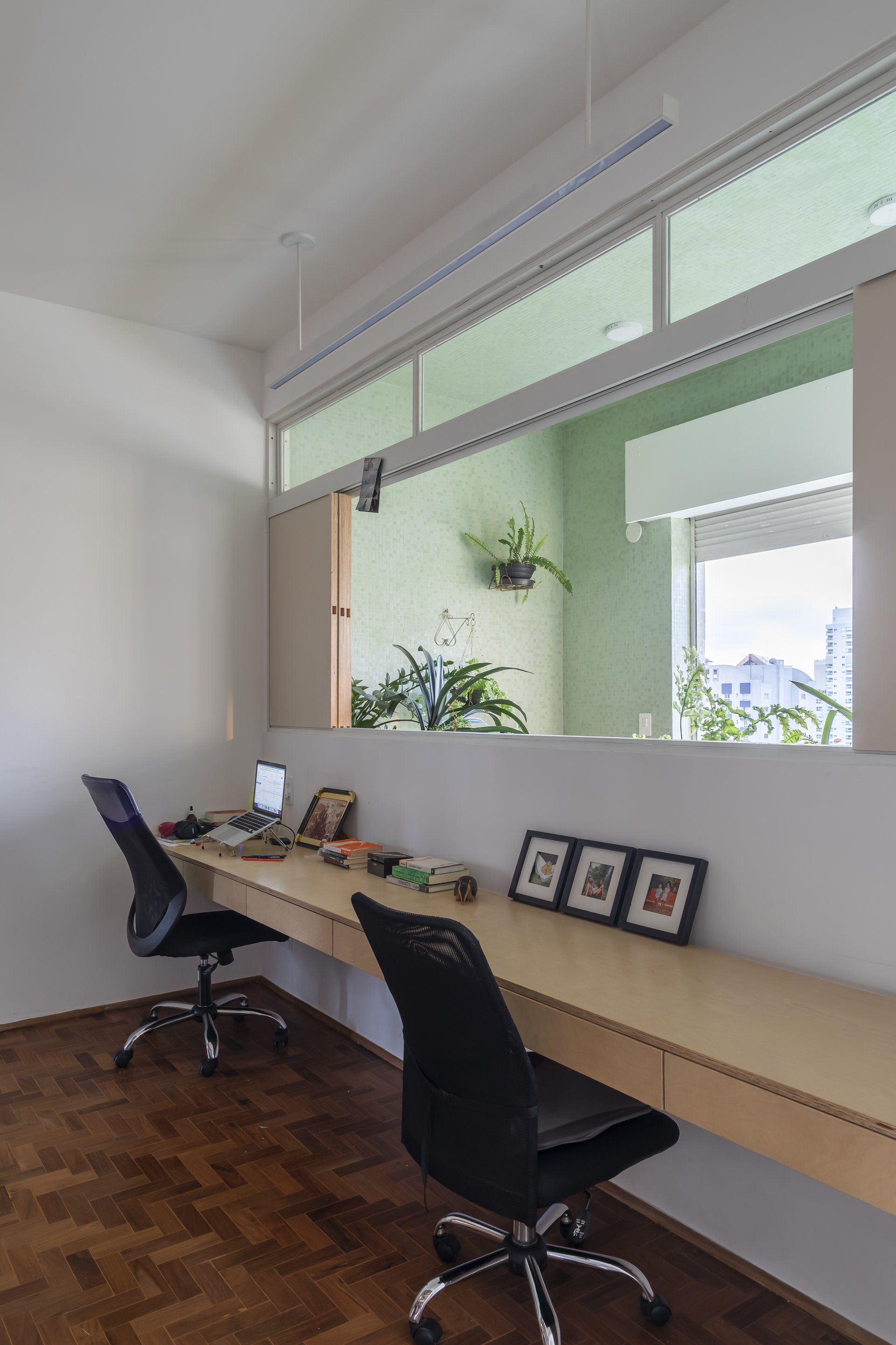 Uma sala com duas mesas e cadeiras e uma grande janela.