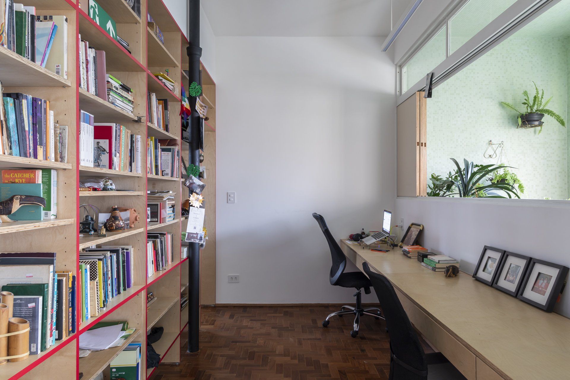 Uma sala com uma escrivaninha e estantes cheias de livros.