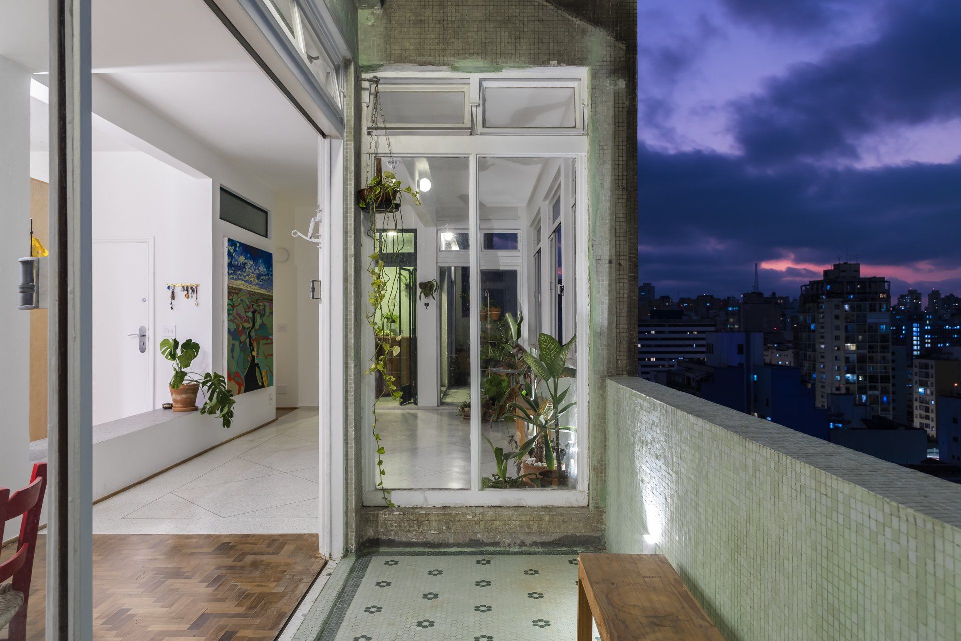 Uma varanda com vista para a cidade à noite.