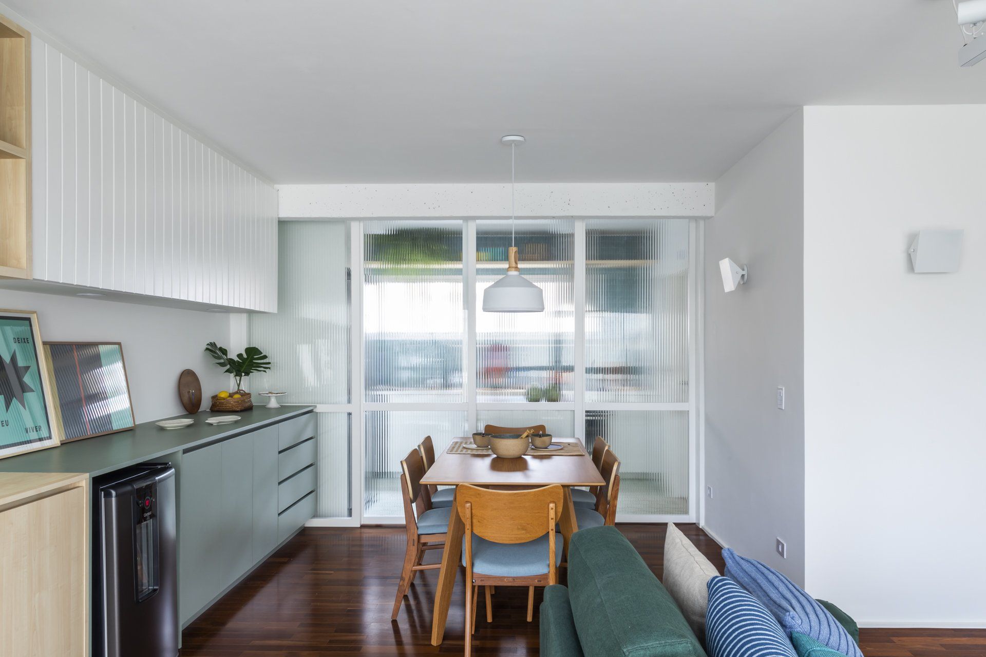 Há uma mesa de jantar e cadeiras no meio da sala.