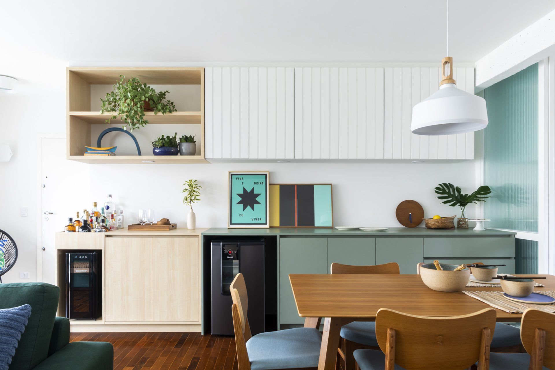Uma cozinha com mesa e cadeiras e geladeira.