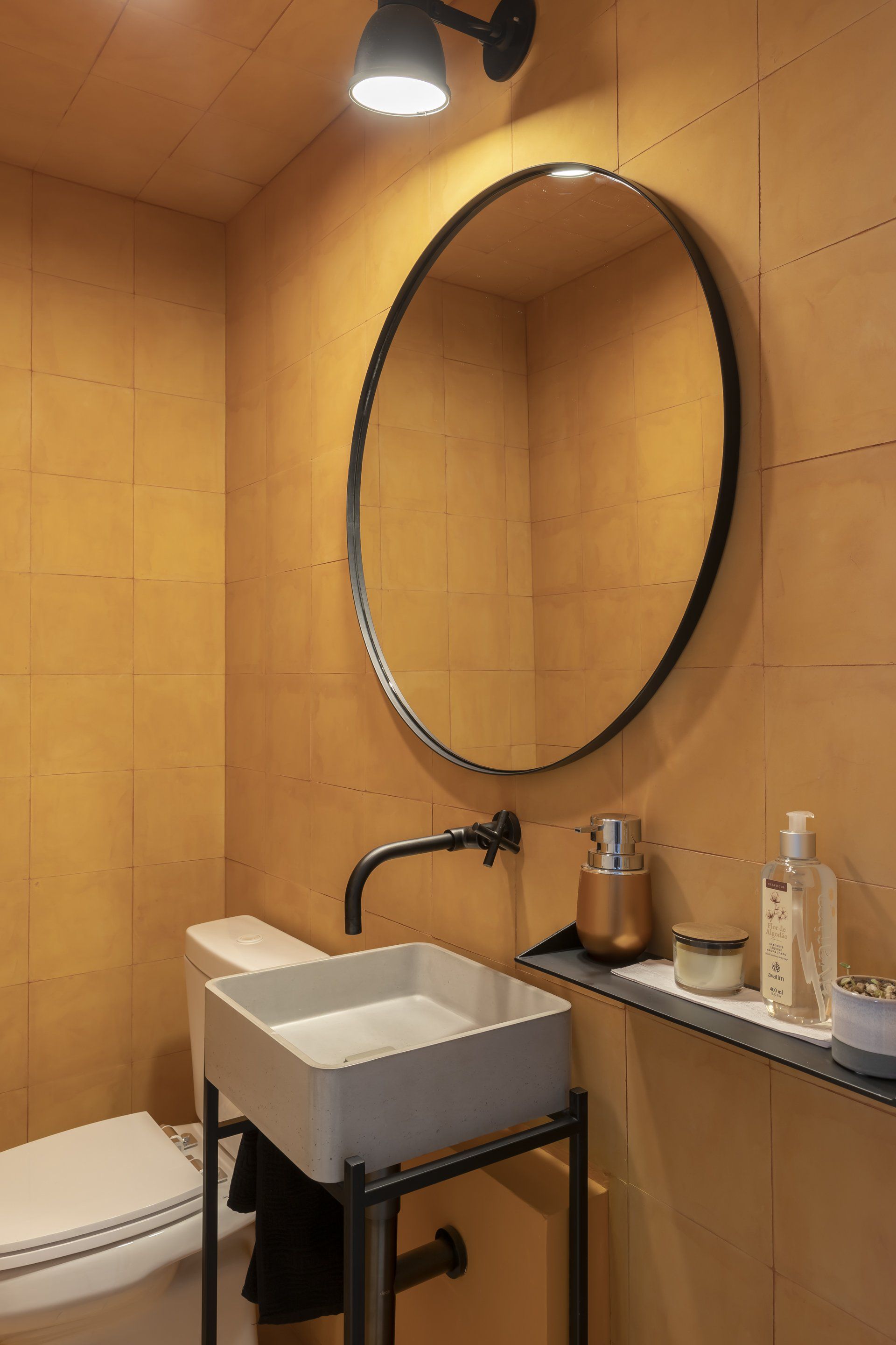 Um banheiro com vaso sanitário, pia e espelho.