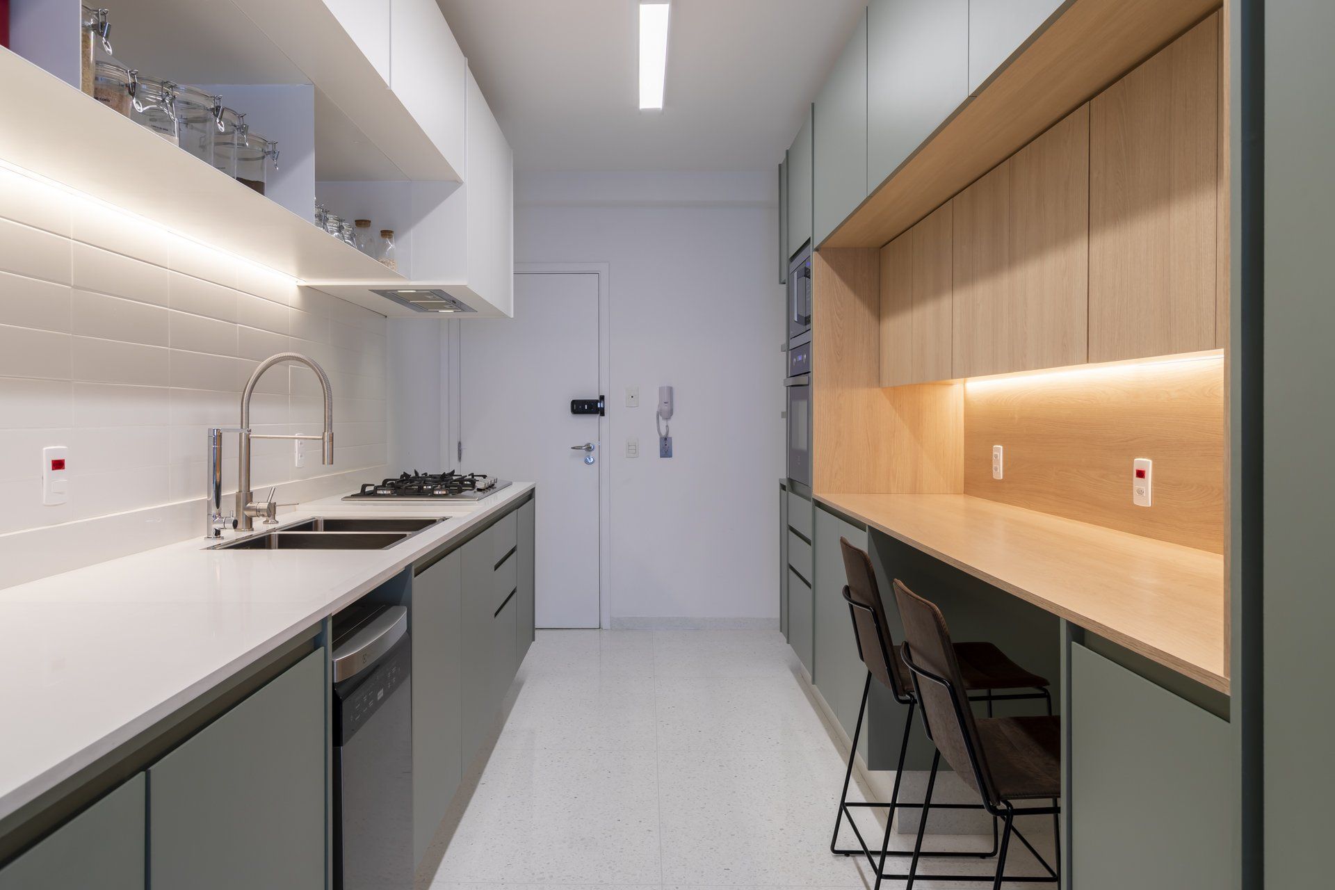 Uma cozinha com duas pias, lava-louças e uma escrivaninha.