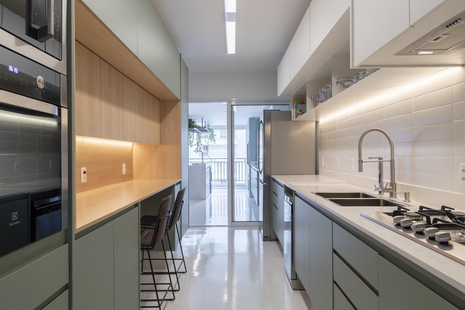 Uma cozinha com pia, fogão, geladeira e micro-ondas.