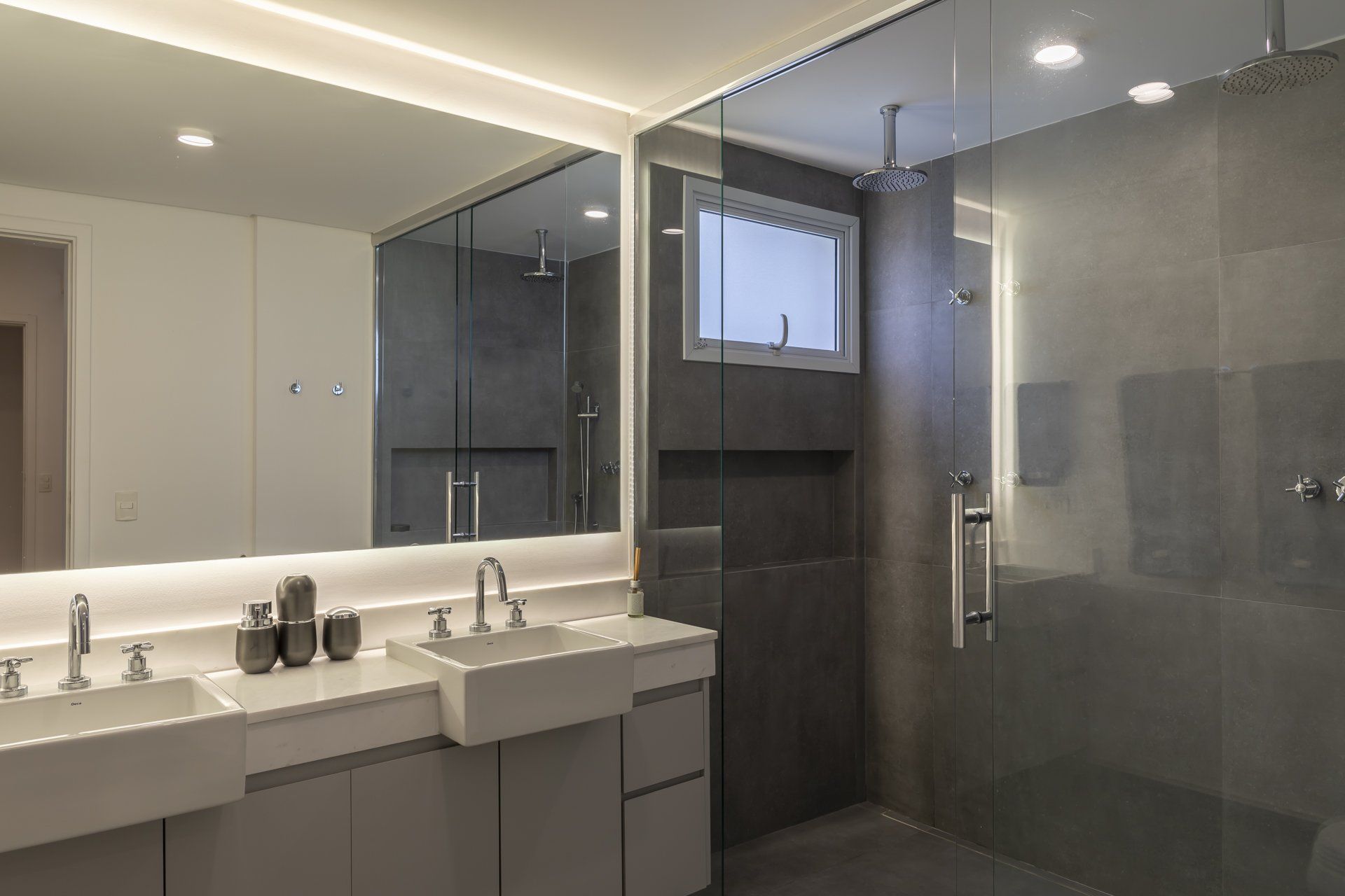 Um banheiro com duas pias e um box amplo.