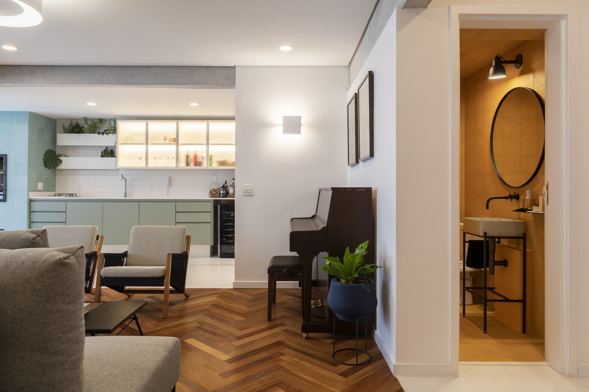 Uma sala de estar com piano, cadeiras, pia e espelho.