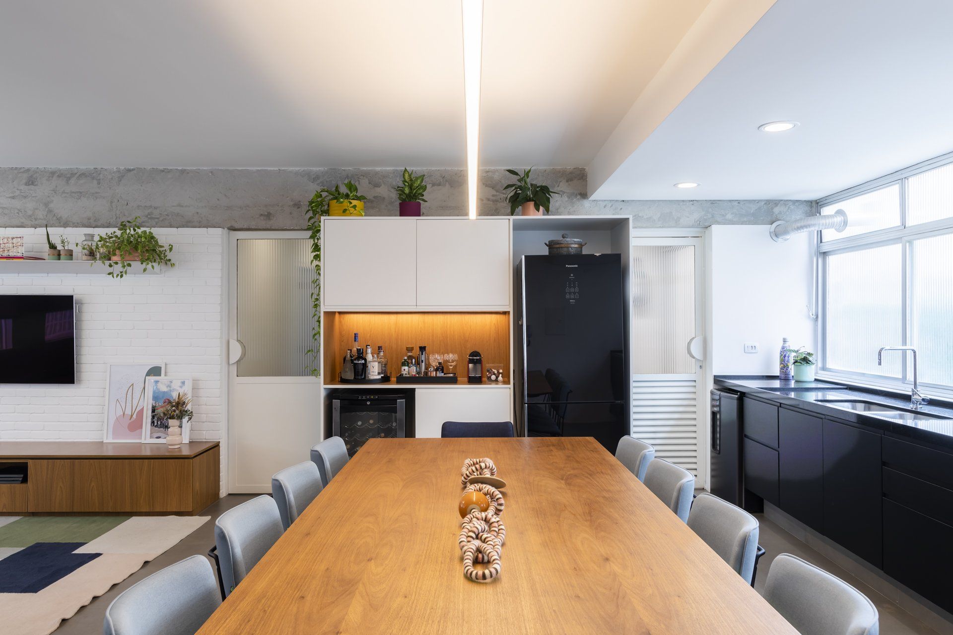 Uma sala de jantar com uma longa mesa e cadeiras de madeira