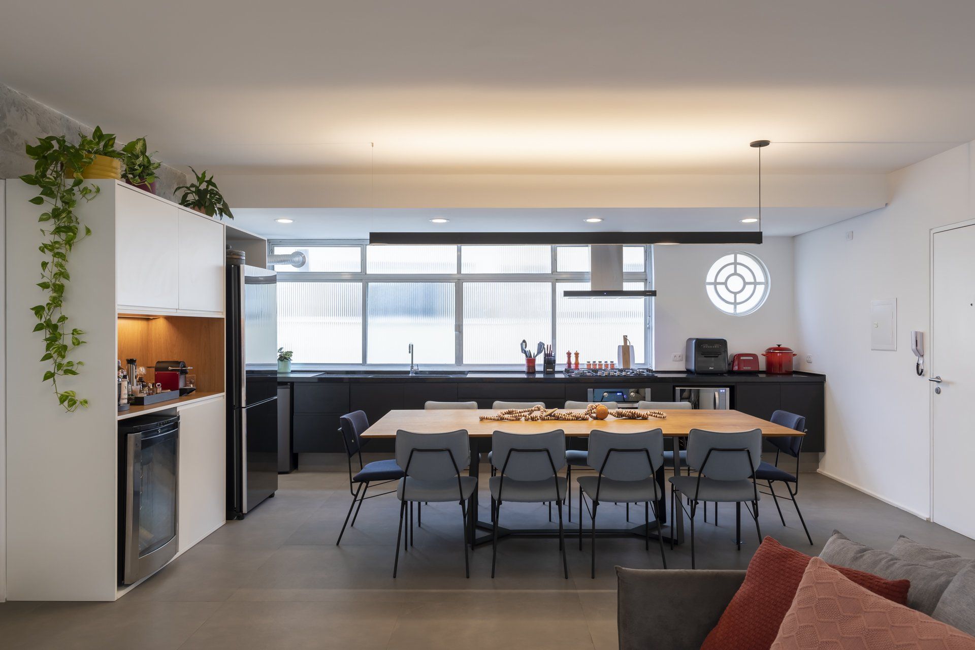 Há uma grande mesa e cadeiras no meio da sala.