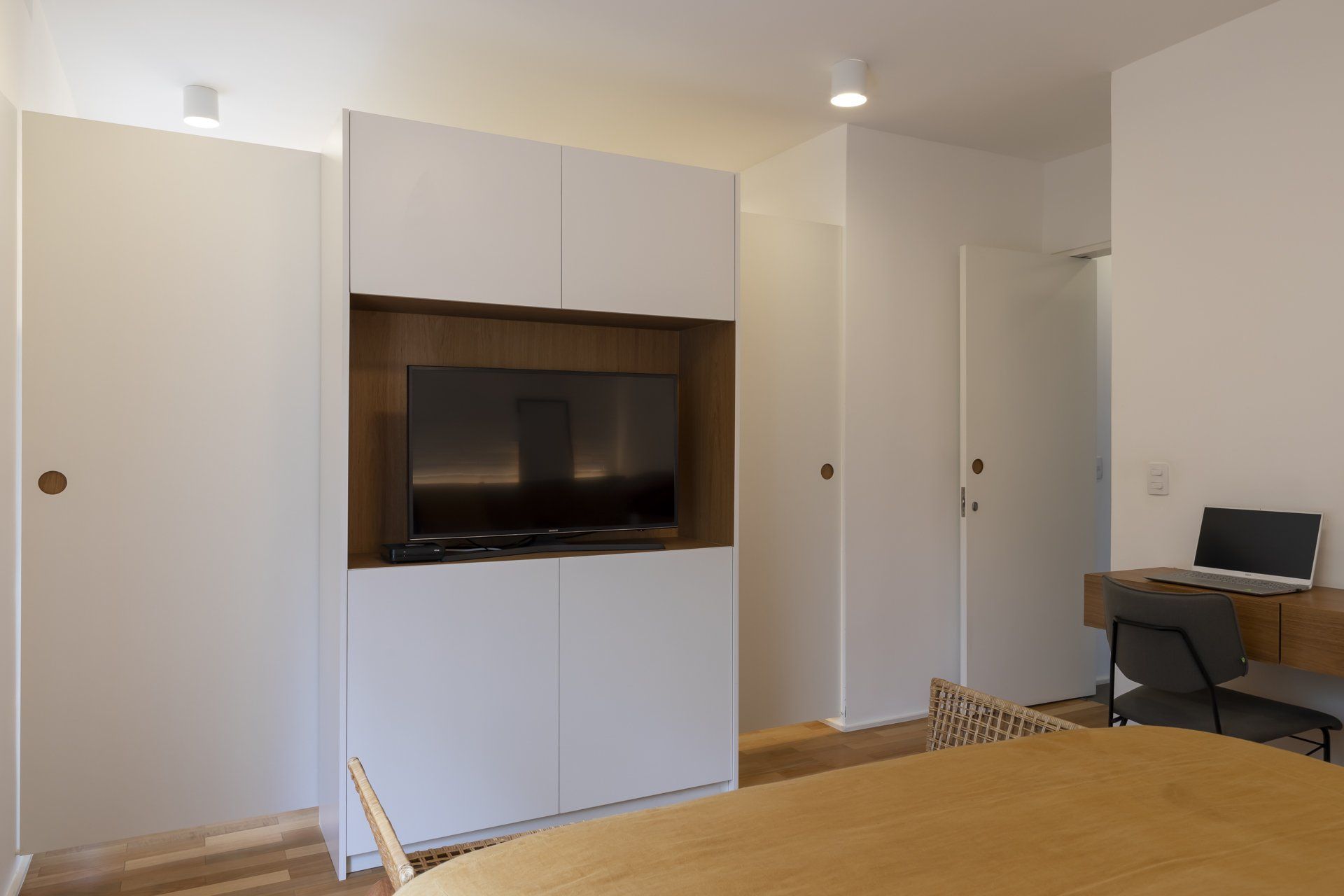 Uma sala de estar com mesa, cadeiras e TV de tela plana.