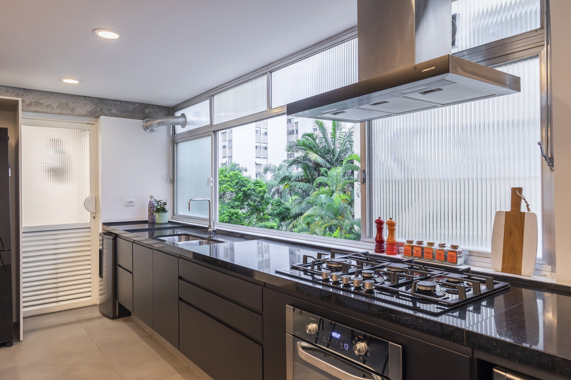 Uma cozinha com fogão, pia e janela.