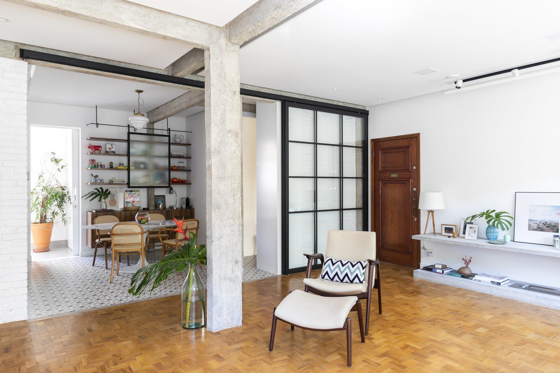 Uma sala de estar com porta de vidro deslizante entre a sala de jantar e a sala de estar.