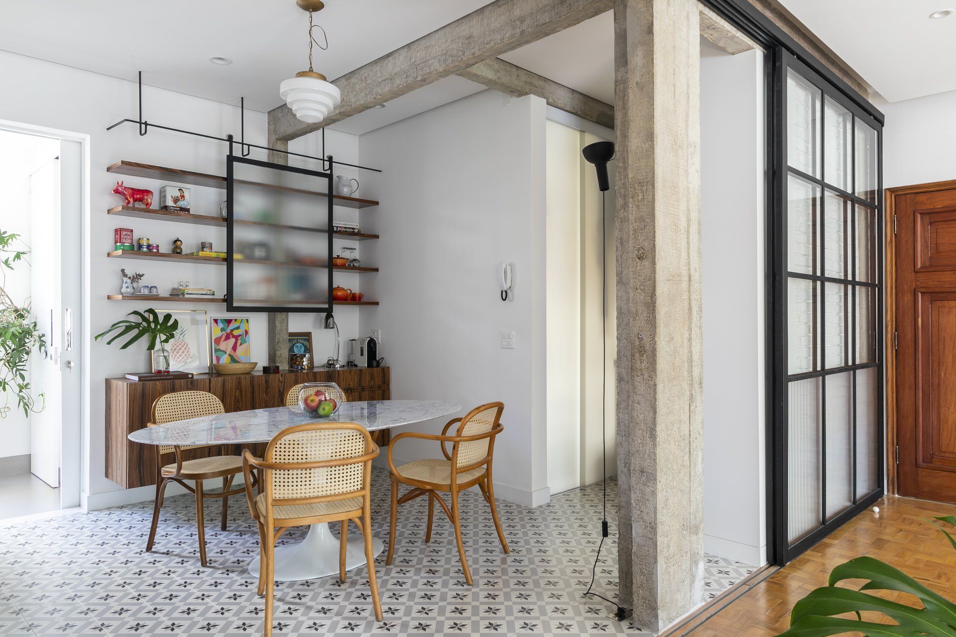 Uma sala de jantar com mesa e cadeiras e porta de vidro deslizante.