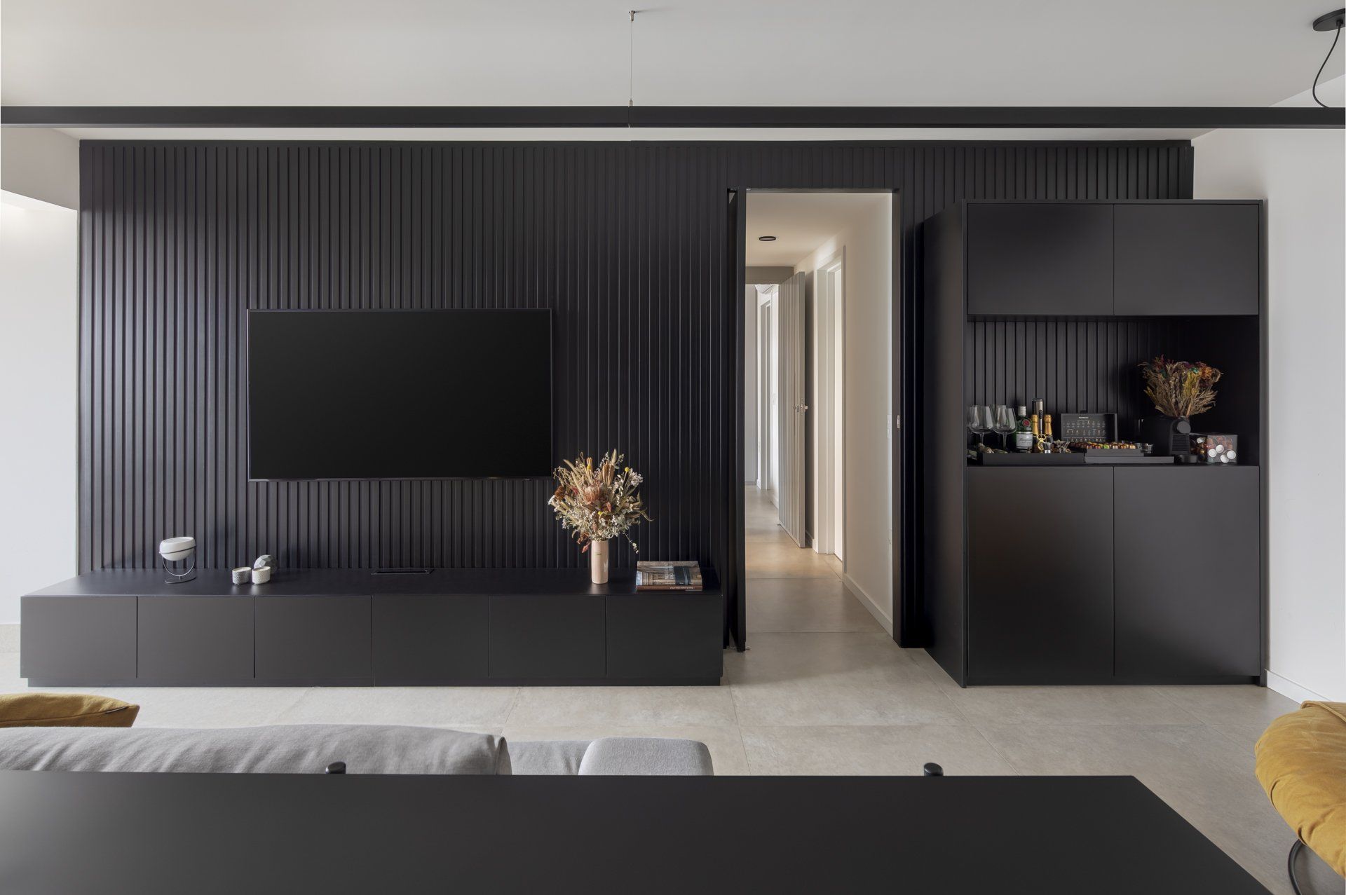 Uma sala de estar com parede preta e TV de tela plana.