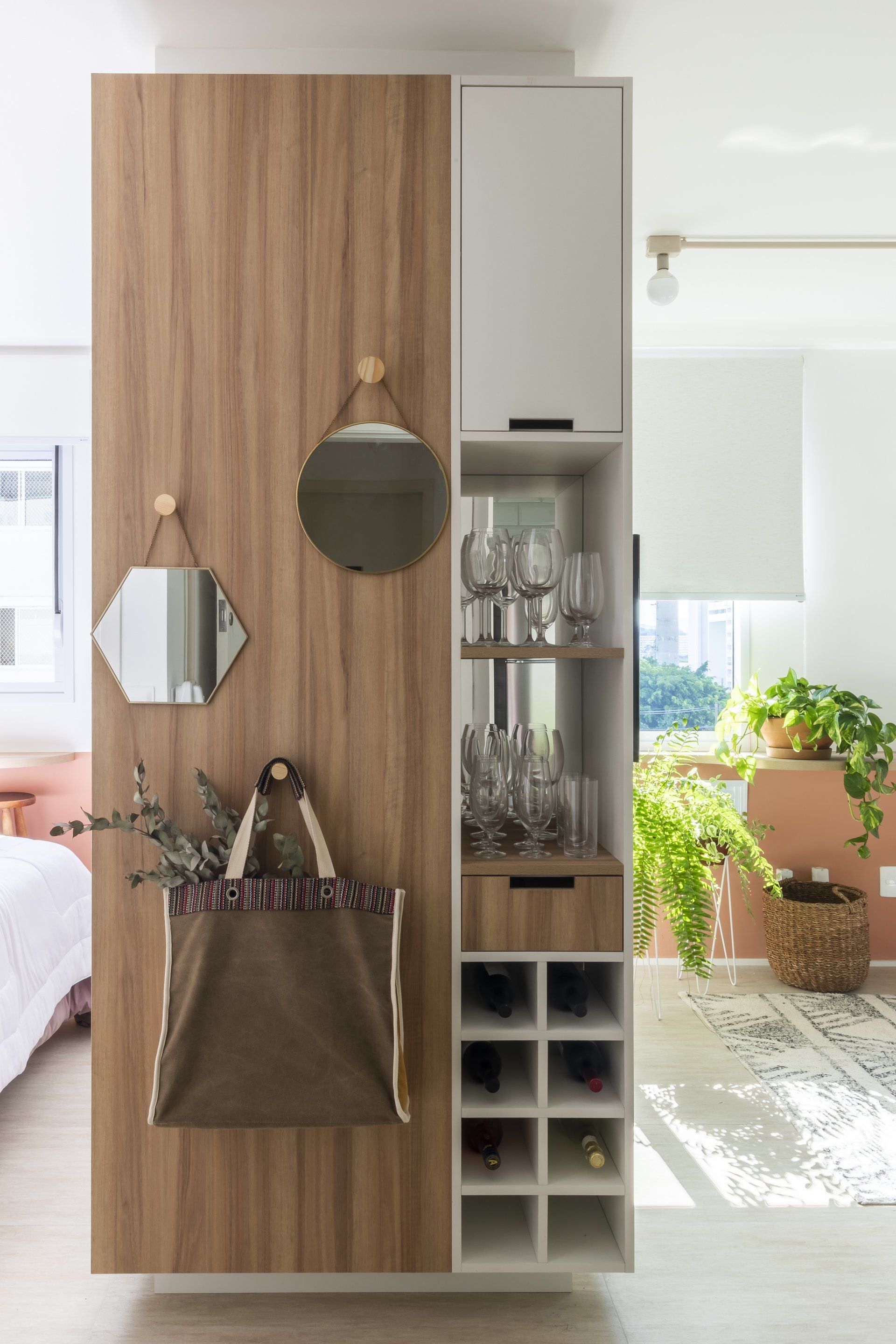 Uma parede de madeira com uma garrafeira e espelhos.