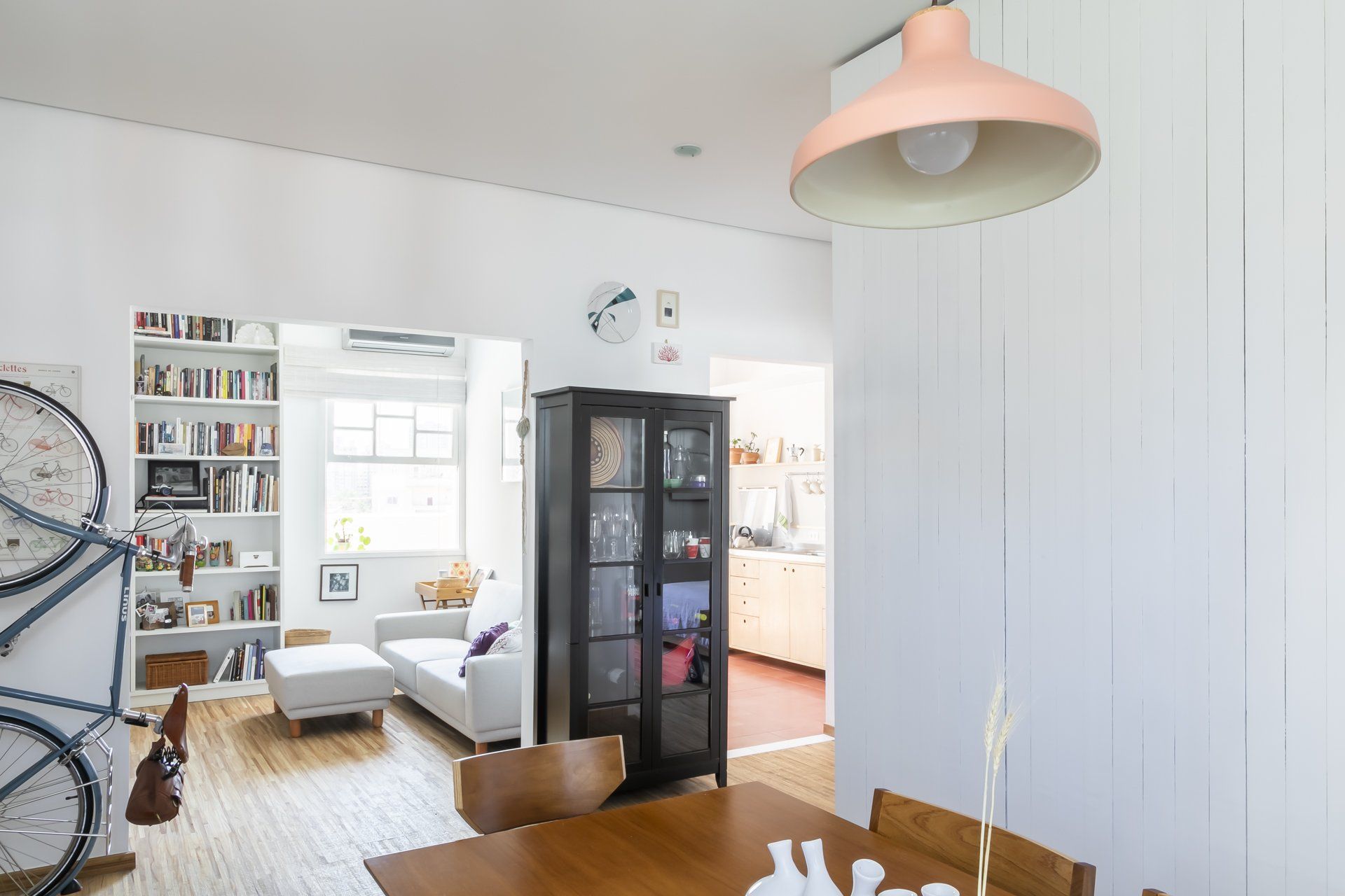 Uma sala de estar com mesa de jantar e cadeiras e uma bicicleta na parede.