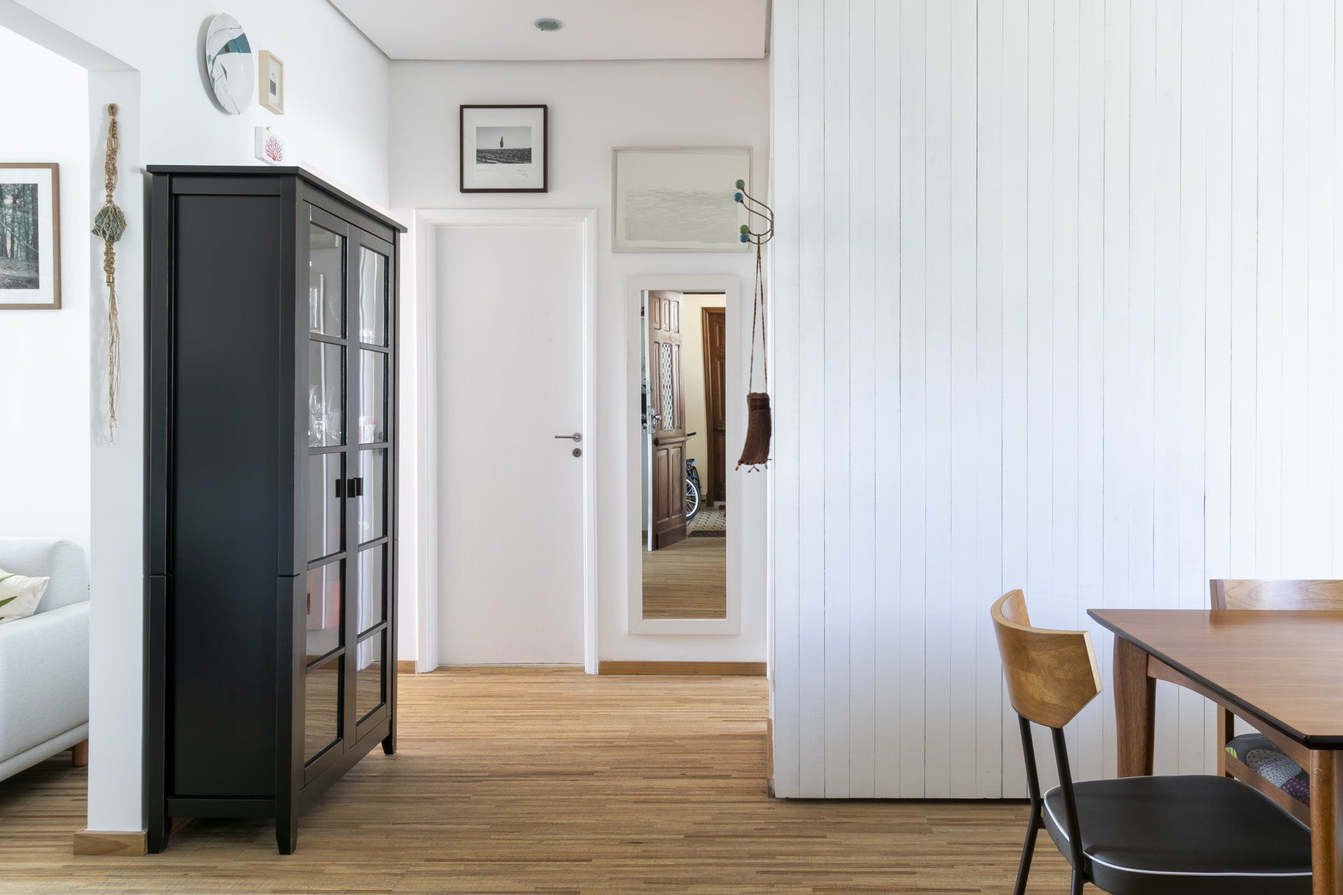 Uma sala com mesa e cadeiras e um armário preto.