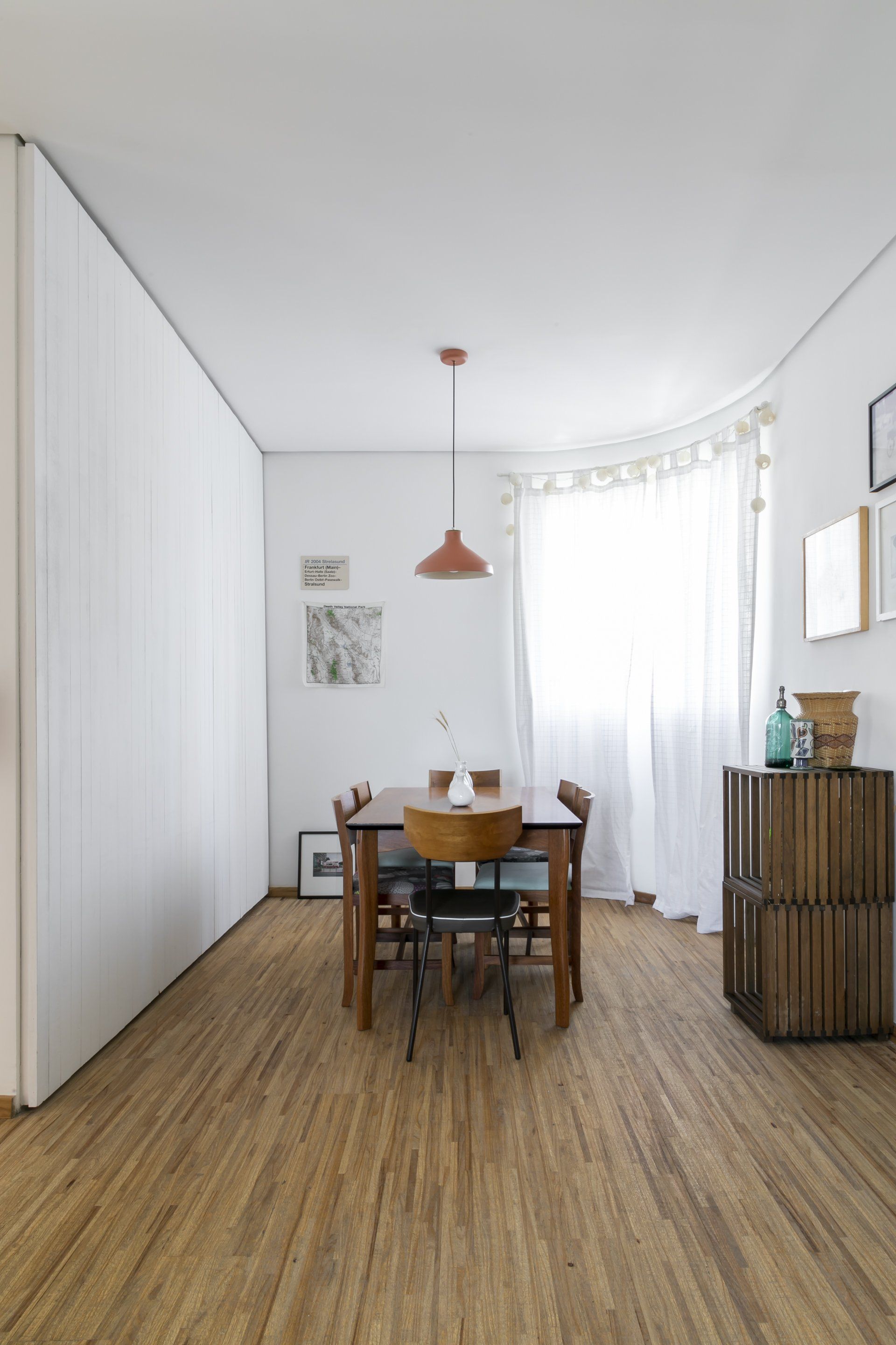 Uma sala de jantar com mesa e cadeiras e piso de madeira.
