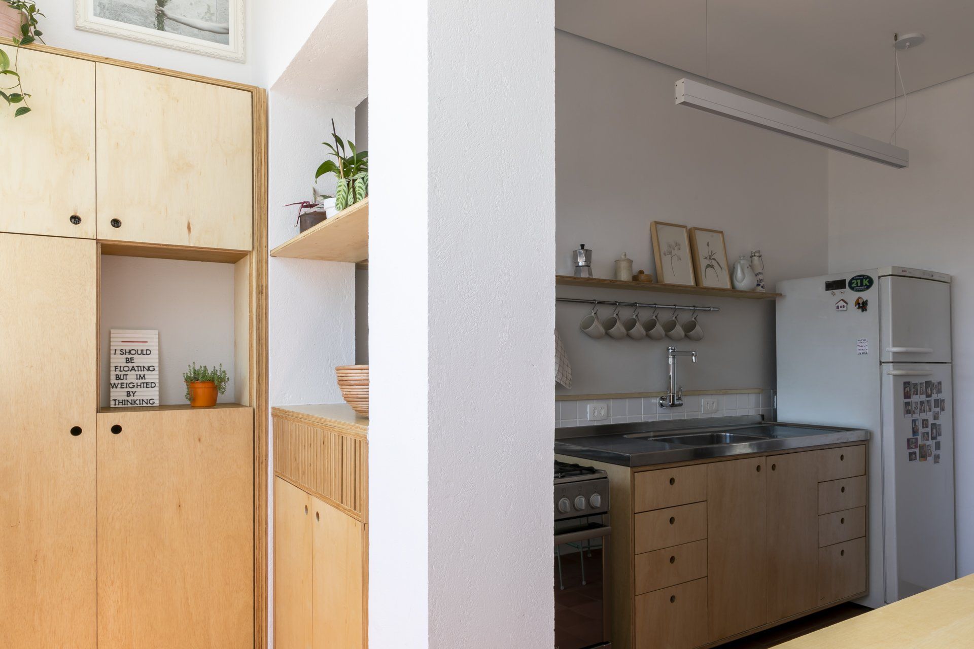 Uma cozinha com armários de madeira e geladeira branca.