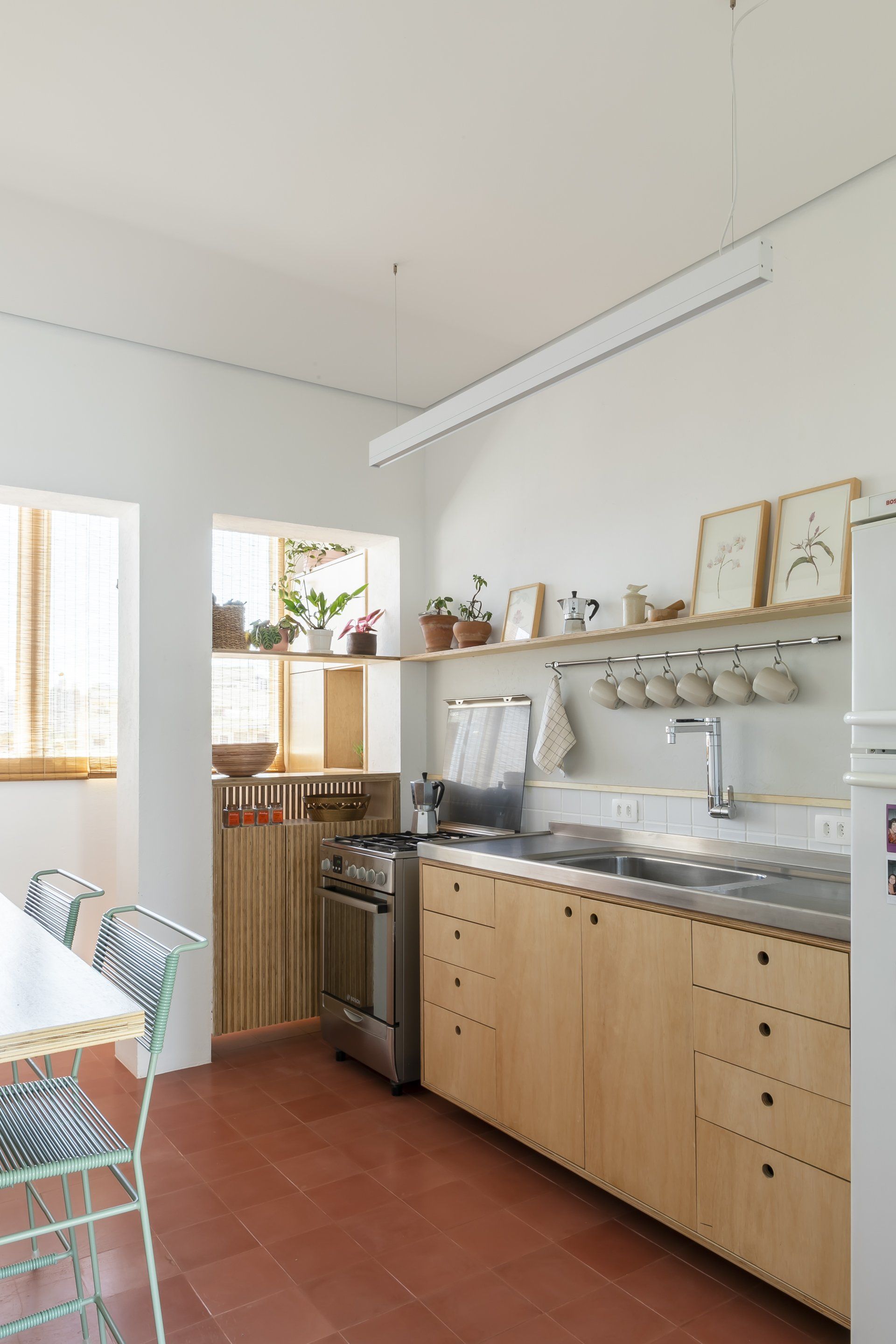 Cozinha com armários de madeira, fogão, pia e geladeira.