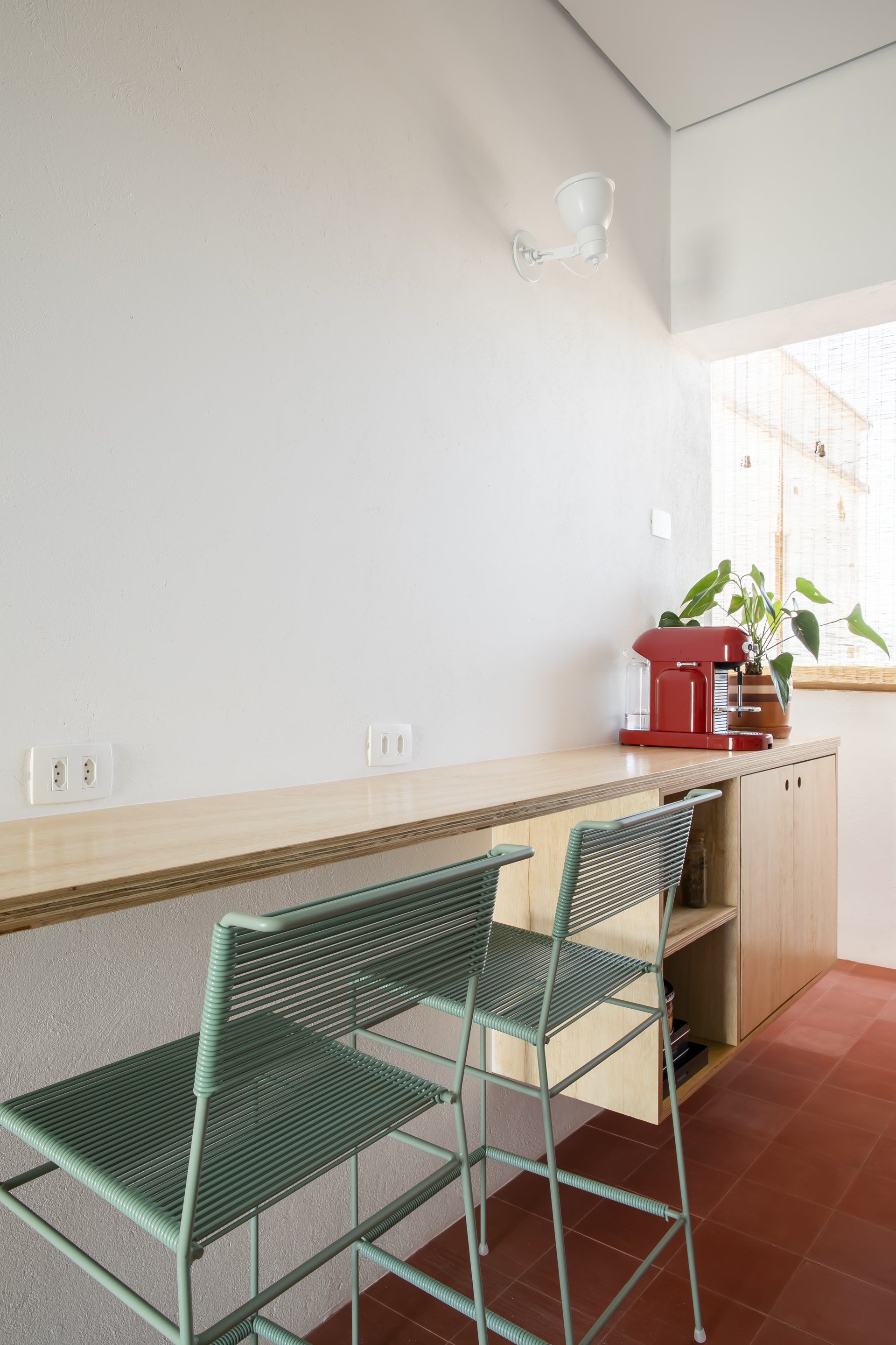 Uma cozinha com mesa e cadeiras e uma cafeteira vermelha.