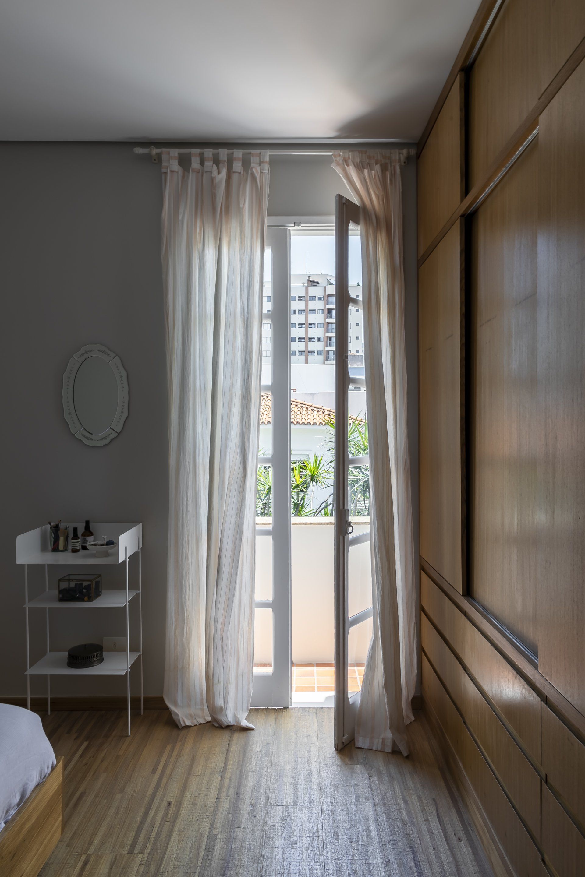 Um quarto com porta de vidro deslizante que dá acesso a uma varanda.