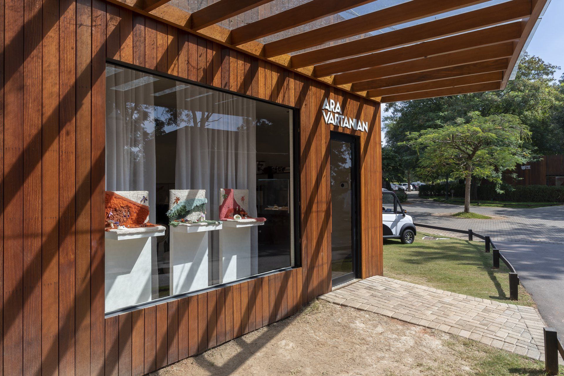 Uma construção de madeira com janela de vidro e pérgula.