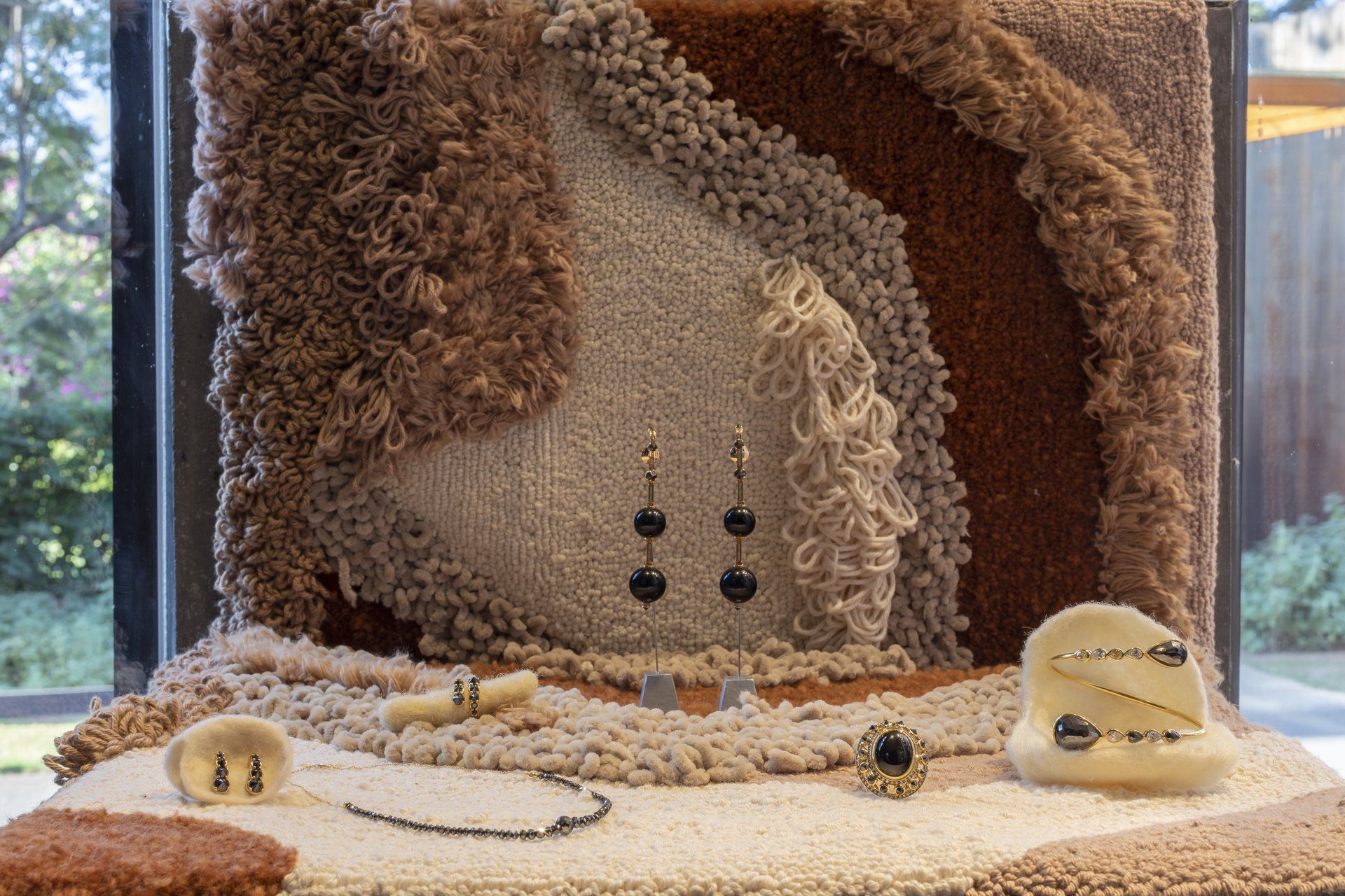 Uma exposição de joias em uma mesa em frente a uma janela.
