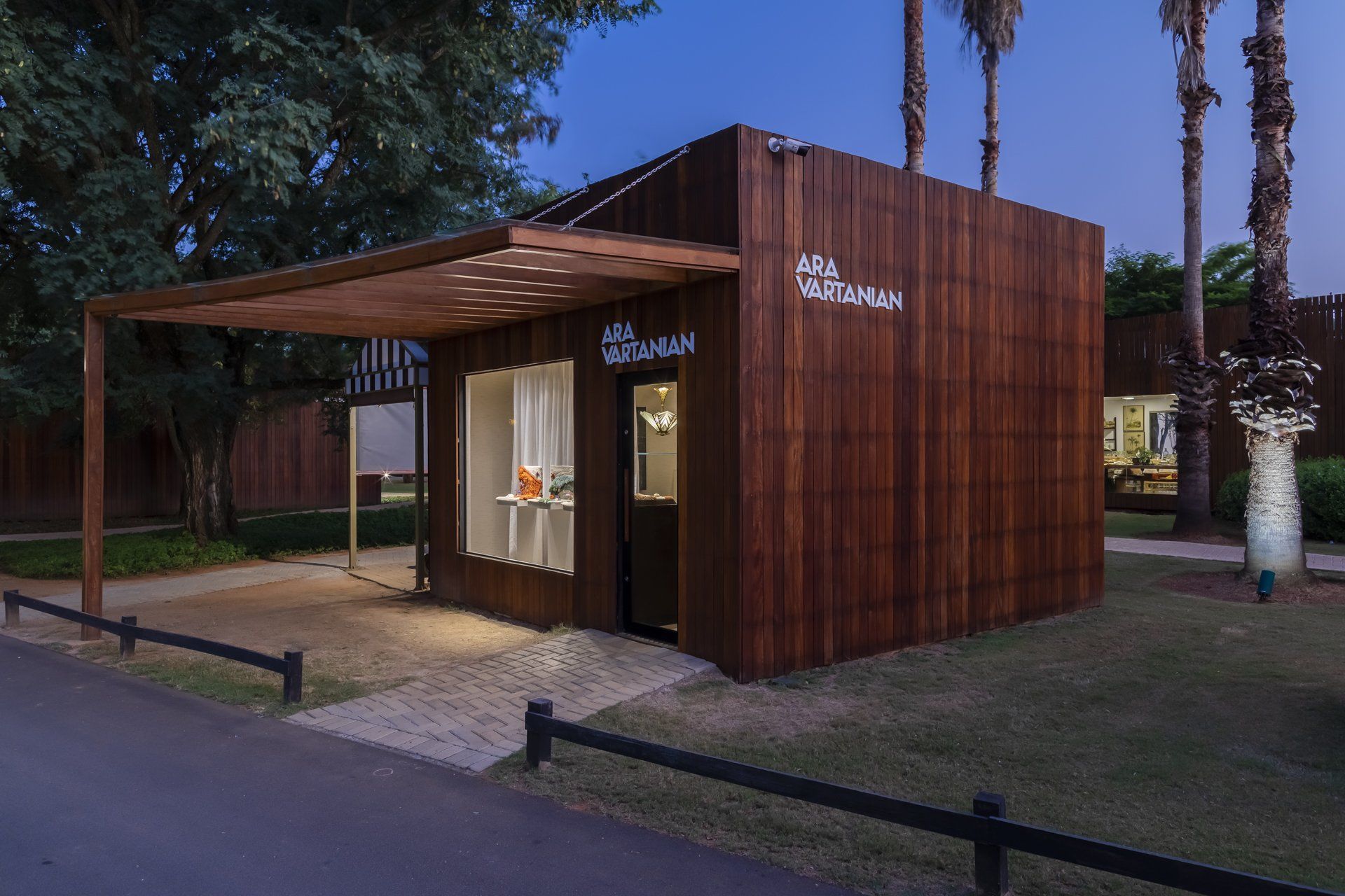 Um pequeno prédio de madeira com uma cerca na frente.